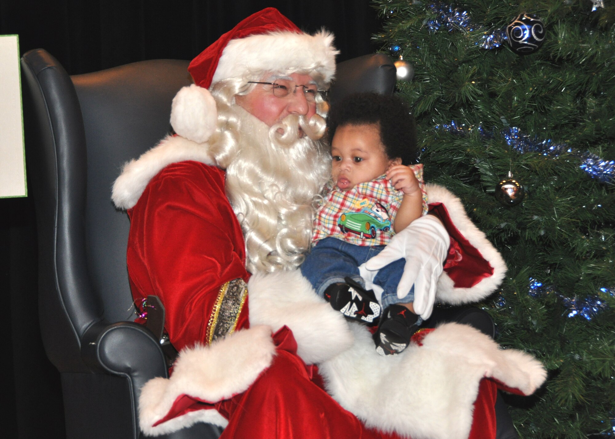 Santa Claus holds 5-month-old Ayden Agee during Saturday’s 81st Medical Group children’s Christmas party in the hospital’s Don Wylie Auditorium. In addition to Santa presenting gifts to scores of children with the help of Mrs. Claus and several elves, the event offered games and food. Ayden’s parents are Senior Airman Kimberly Delus, 81st Surgical Operations Squadron, and Gene Agee. Other units across the base have already had their holiday parties and others have planned their celebrations for this weekend.  (U.S. Air Force photo by Steve PIvnick)