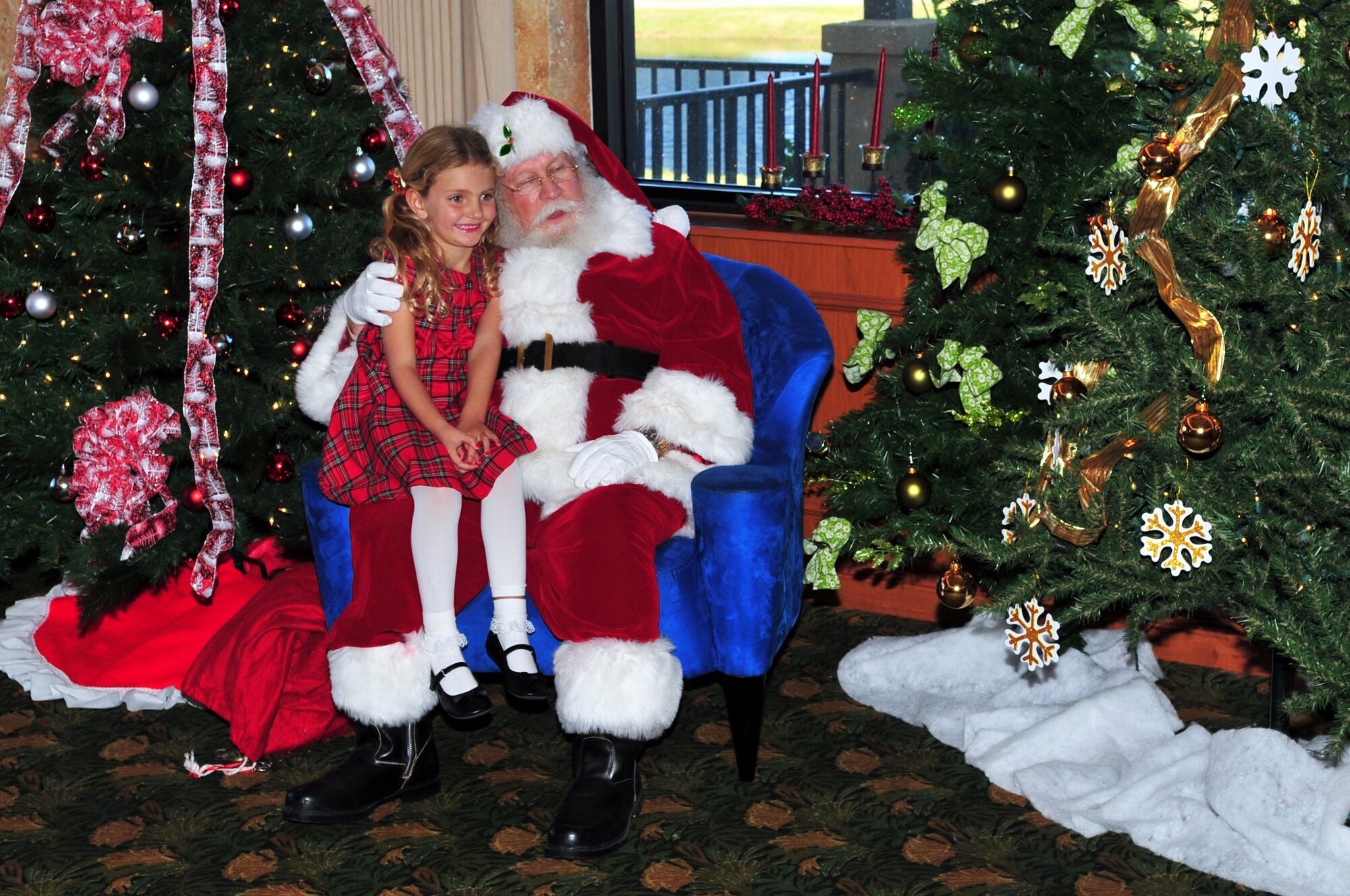 Lauren Williams, 5, daughter of Air Force Maj. (Ret.) Kenneth and Sophie Williams, is all smiles as she poses with Santa during the 45th Space Wing Holiday Party held Dec. 10 at the Manatee Cove Golf Course. The Satellite Beach family was one of several hundred people who turned out for the fun-filled festival.  
