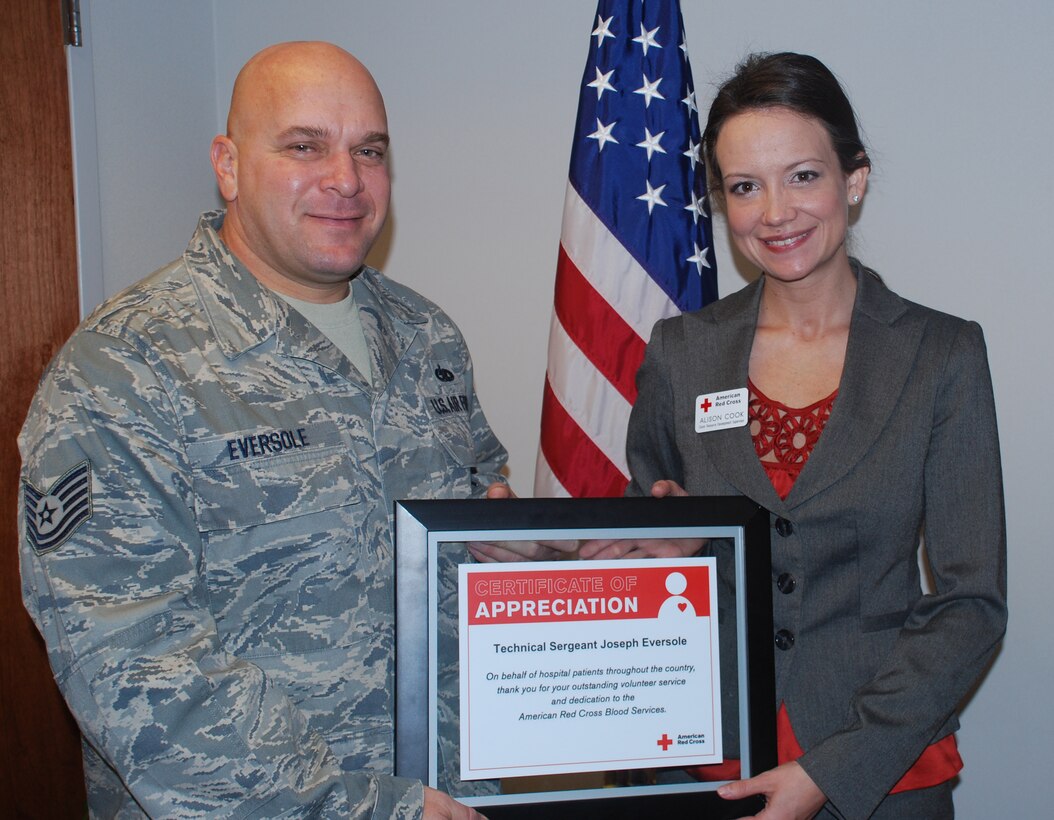 Alison Cook, right, the American Red Cross donor recruitment supervisor for Texas, presents a certificate of appreciate to Tech. Sgt. Joseph Eversole Dec. 15. The 982nd Maintenance Squadron Airman was recognized for his efforts to coordinate an event that produced enough blood to save 2,250 lives. (U.S. Air Force photo/John Ingle)