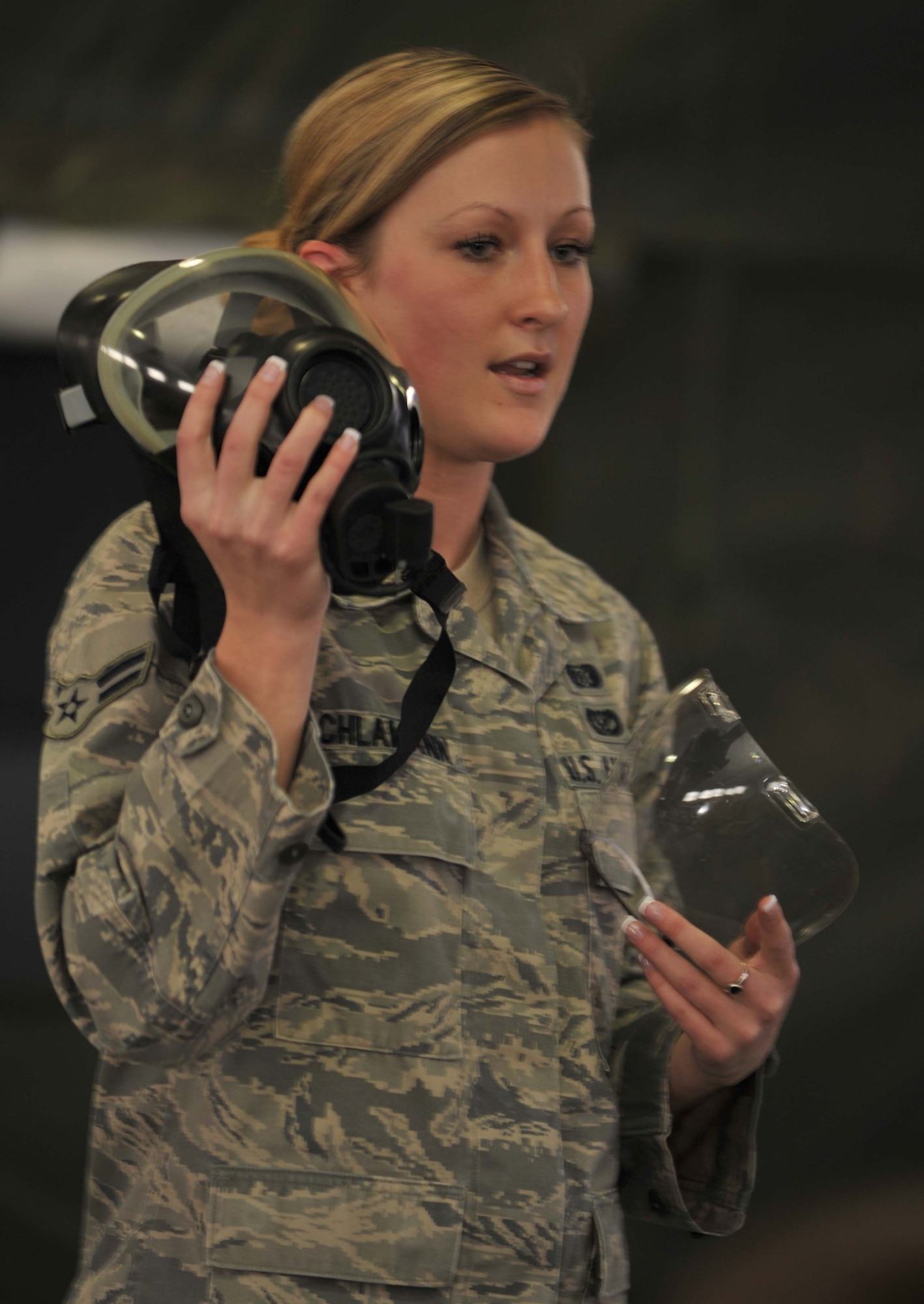 Airman 1st Class Nicole Schlamann, 22nd Civil Engineer Squadron Readiness and Emergency Management journeyman, instructs McConnell Airmen on how to inspect their gas masks during a Chemical, Biological, Radiological and Nuclear Challenge class, Dec. 15, 2010 McConnell Air Force Base, Kan.  In addition to instructing CBRN classes, the Lincoln, Neb., native is in charge of the Emergency Management flight training section and organizes in-house training for the Emergency Management flight.  (U.S. Air Force photo/Senior Airman Abigail Klein)