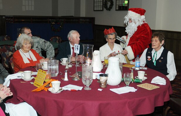 RAF MILDENHALL, England -- Santa hands out gifts during the 29th Annual Senior Citizens Luncheon here Dec. 16, 2010. This event was organized by the Top Three and sponsored by several base organizations to help maintain partnerships with the local communities. (U.S. Air Force photo/Senior Airman Tabitha M. Lee)