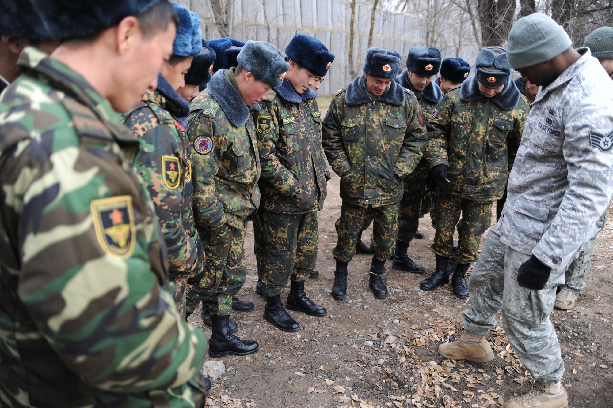 TRANSIT CENTER AT MANAS, Kyrgyzstan - Staff Sgt. Martin Strom, Explosive Ordnance Disposal team member, explains the functions of a pressure plate as part of an exercise scenario used to share basic EOD operations during a U.S.-Kygyz military-to-military event held at the Transit Center at Manas Dec. 16.  This event increases overall awareness and sharpens EOD skills improving the ability to defend against extremist organizations who use unexploded ordnance and improvised explosive devices. (U.S. Air Force photo/Staff Sgt. Nathan Bevier)
