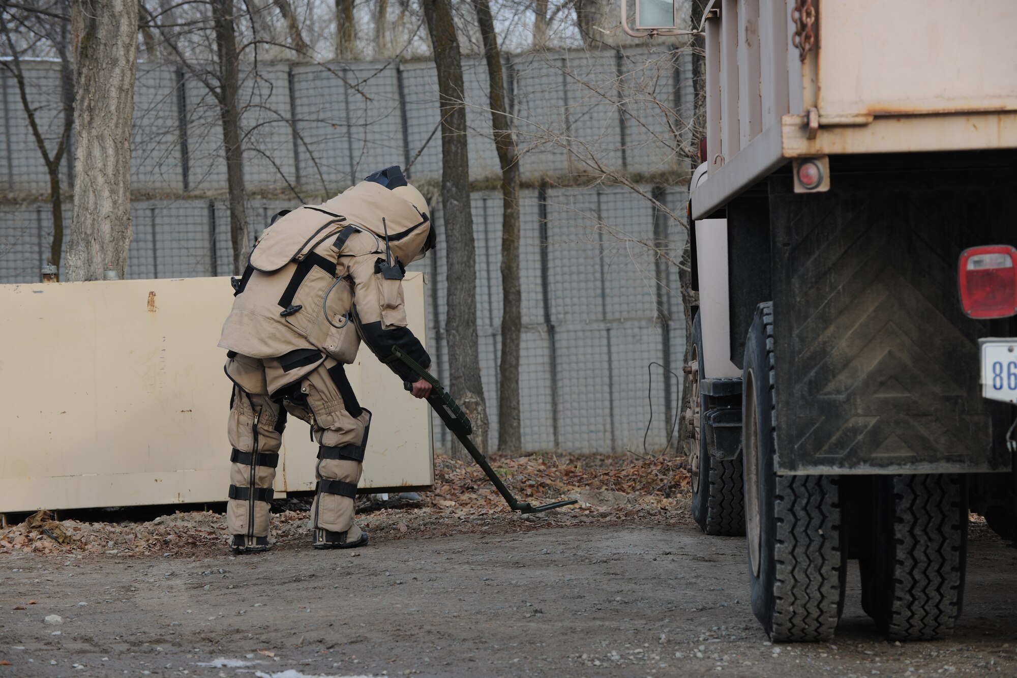 TRANSIT CENTER AT MANAS, Kyrgyzstan - A Kyrgyz Explosive Ordnance Disposal team member searches for improvised explosive devices as part of an exercise scenario used to share basic EOD operations during a U.S.-Kygyz military-to-military event held at the Transit Center at Manas Dec. 16.  This event increases overall awareness and sharpens EOD skills improving the ability to defend against extremist organizations who use unexploded ordnance and improvised explosive devices. (U.S. Air Force photo/Staff Sgt. Nathan Bevier)