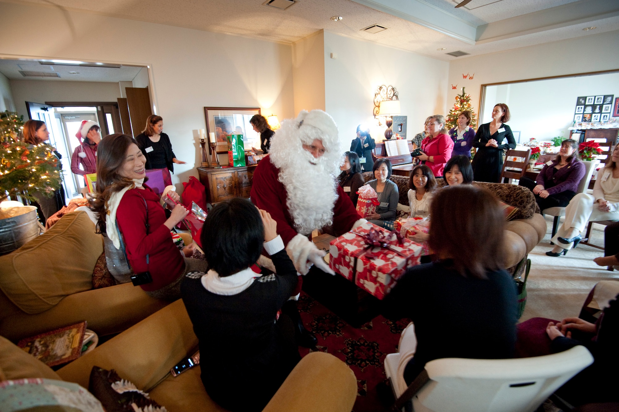 Santa delivers presents to the American and Japanese officers' spouses clubs during a bilateral social event, sharing the American holiday spirit with Japanese military spouses at the Rothsteins' home, Misawa Air Base, Japan; Dec. 10, 2010. The military spouses meet regularly to support each other and strengthen the relationship of the U.S. Air Force and Japan Air Self-Defense Force stationed at Misawa Air Base. (U.S. Air Force photo by Staff Sgt. Samuel Morse/Released)