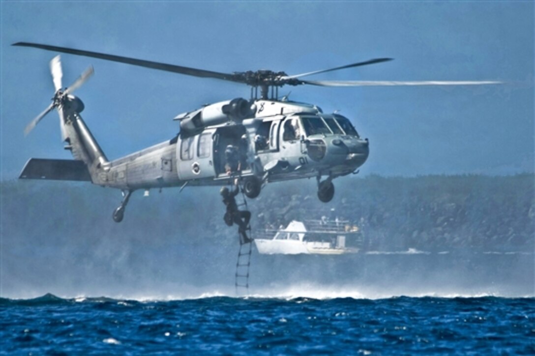 A U.S. Marine climbs a rope ladder to an MH-60S Seahawk helicopter during helocast training as part of exercise Sandfisher with the Singapore Armed Forces at Sanat Rita, U.S. Naval Base Guam, Dec. 13, 2010. The Marine is assigned to 3rd Reconnaissance Battalion, Okinawa, Japan. The helicopter is assigned to Helicopter Sea Combat Squadron 25.