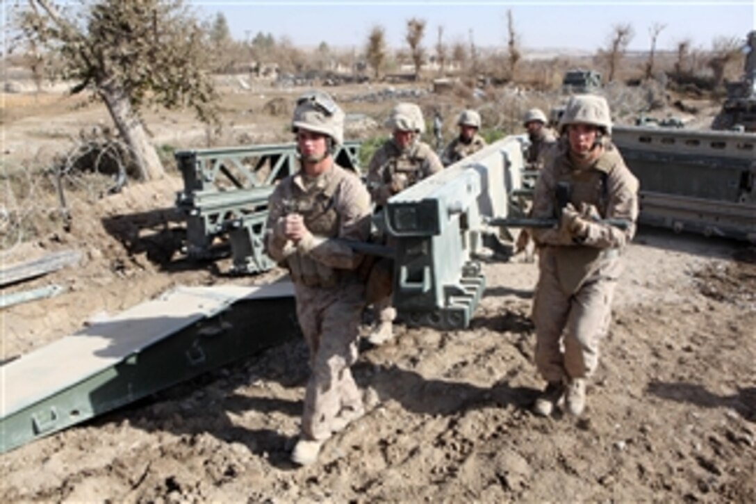 U.S. Marines with the 8th Engineer Support Battalion, 1st Marine Logistics Group carry bridge components to be assembled during a bridge emplacement mission in the Sangin district of Helmand province, Afghanistan, on Dec. 9, 2010.  The 8th Engineer Support Battalion conducted engineering operations for coalition forces and area residents in support of the International Security Assistance Force.  