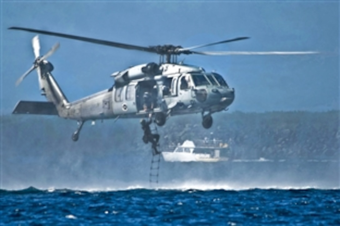 A U.S. Marine climbs a rope ladder to an MH-60S Seahawk helicopter during helocast training as part of exercise Sandfisher with the Singapore Armed Forces at Sanat Rita, U.S. Naval Base Guam, Dec. 13, 2010. The Marine is assigned to 3rd Reconnaissance Battalion, Okinawa, Japan. The helicopter is assigned to Helicopter Sea Combat Squadron 25.