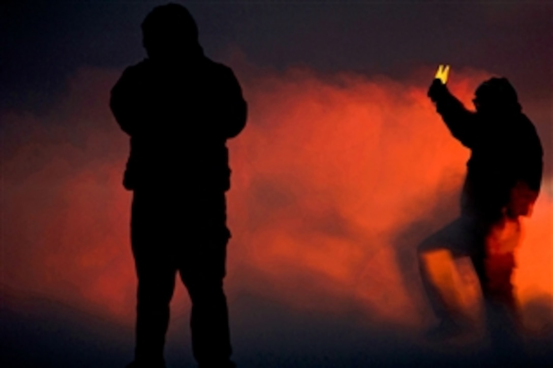 A U.S. Navy sailor guides an F/A-18C Hornet onto a steam-powered catapult at dusk on the flight deck of the aircraft carrier USS Carl Vinson in the Pacific Ocean, Dec. 15, 2010. The Carl Vinson and Carrier Air Wing 17 are conducting a three-week training exercise before a deployment to the western Pacific Ocean.