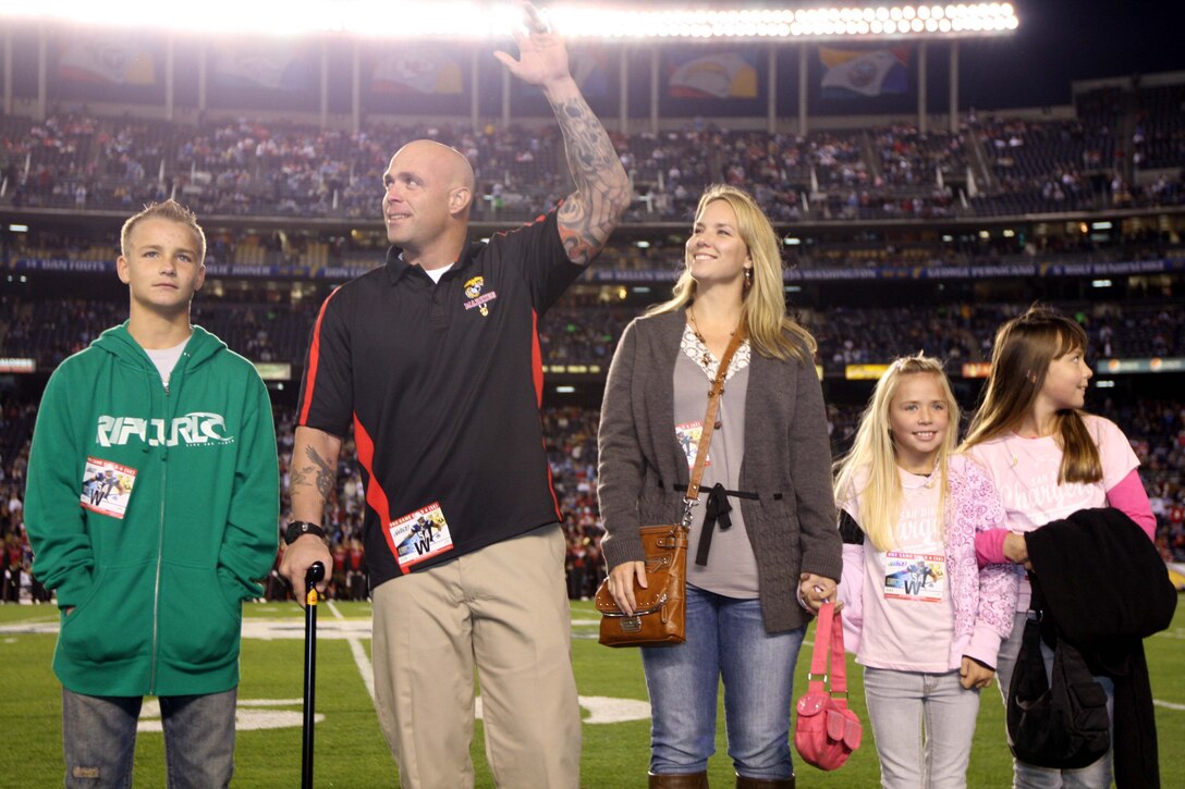 Gunnery Sgt. Christopher Carlisle, 3rd Battalion, 5th Marine Regiment, 1st Marine Division, waves to the crowd as he is recognized as a Hometown Hero during the San Diego Chargers pregame show Dec. 16. Carlisle received two Purple Hearts and a Bronze Star medal, he is currently recovering from wounds he received while conducting combat operations in Afghanistan. Carlisle is accompanied by his wife, Brooke and children, Dylan, Hailey and Megan.