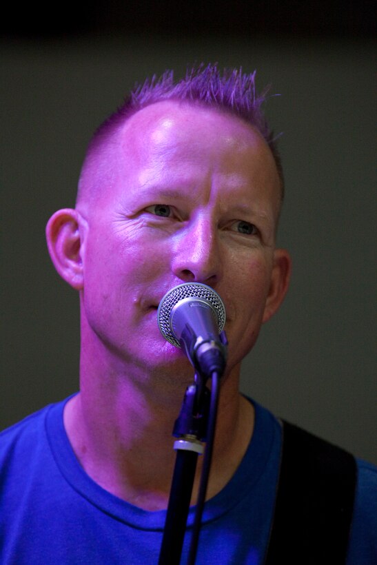 Gunnery Sgt. Clinton W. Walker, supply chief for Headquarters and Service Battalion, U.S. Marine Corps Forces, Pacific, rocks the mic as the lead singer and guitarist for “Rudy and the Sleigh Rockers” Dec. 17 during the MarForPac Christmas Party at Marine Corps Base Hawaii, Kaneohe Bay.::r::::n::Walker and his band mates, a bassist and drummer with the MarForPac Band, change the name of their band to suite the audience and occasion for each performance.