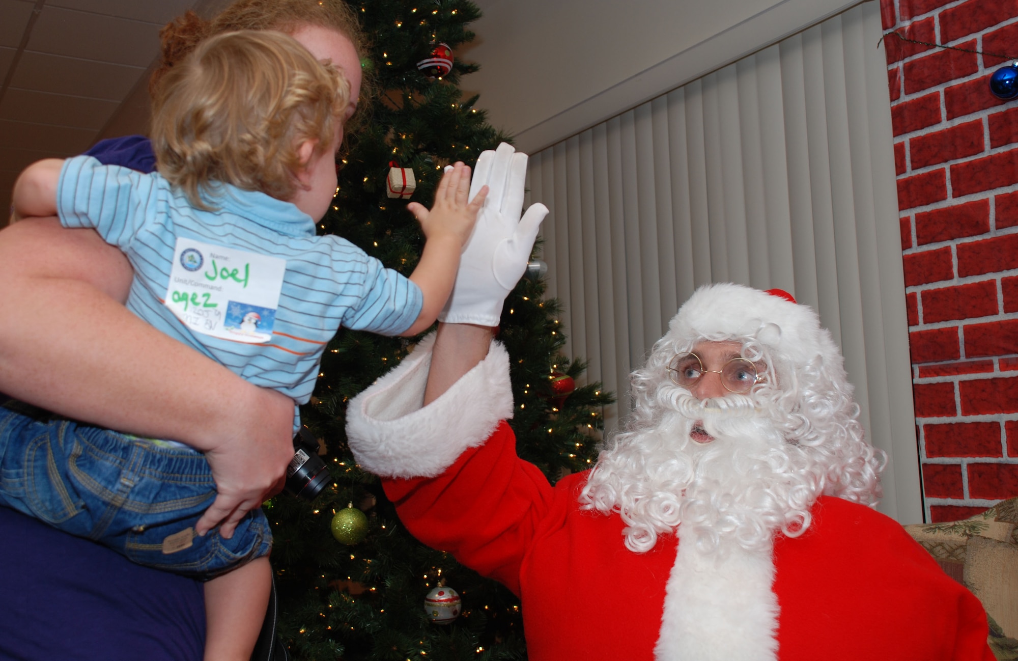 A young boy high-fives Santa during the Deployed Spouse's Christmas Party Dec. 14 at the Hickam Communities Center, Joint Base Pearl Harbor-Hickam, Hawaii. The 647th Air Base Group, with Warfighter Family Readiness Services, hosted the party. More than 55 families, including 111 children attended. Col. Rusty Baumgardner, 647 ABG commander and JBPH-H deputy commander, and many other key leaders provided entertainment and support for families in attendance. The evening concluded with a visit from Santa Clause who provided a present to each of the good boys and girls at the party. (U.S. Air Force photo/Tech. Sgt. Anthony O'Brien)