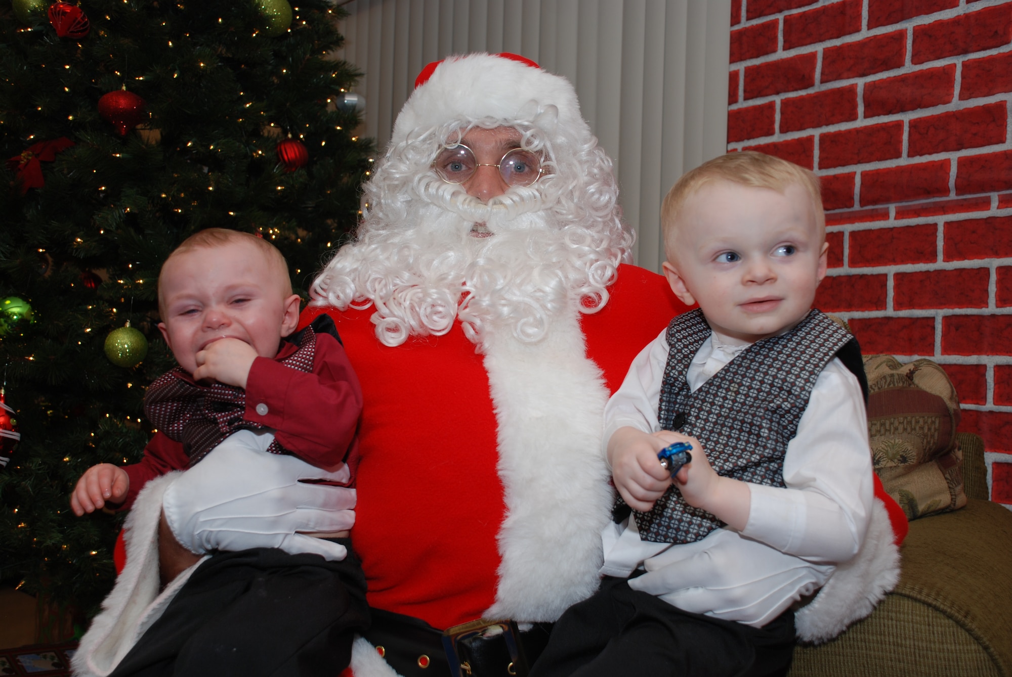 Two children sit on Santa's lap during the Deployed Spouse's Christmas Party Dec. 14 at the Hickam Communities Center, Joint Base Pearl Harbor-Hickam, Hawaii. The 647th Air Base Group, with Warfighter Family Readiness Services, hosted the party. More than 55 families, including 111 children attended. Col. Rusty Baumgardner, 647 ABG commander and JBPH-H deputy commander, and many other key leaders provided entertainment and support for families in attendance. Miss Teen South Pacific World 2011 Cassie Sumimoto read a Christmas story to the children. The evening concluded with a visit from Santa Clause who provided a present to each of the good boys and girls at the party. (U.S. Air Force photo/Tech. Sgt. Anthony O'Brien)