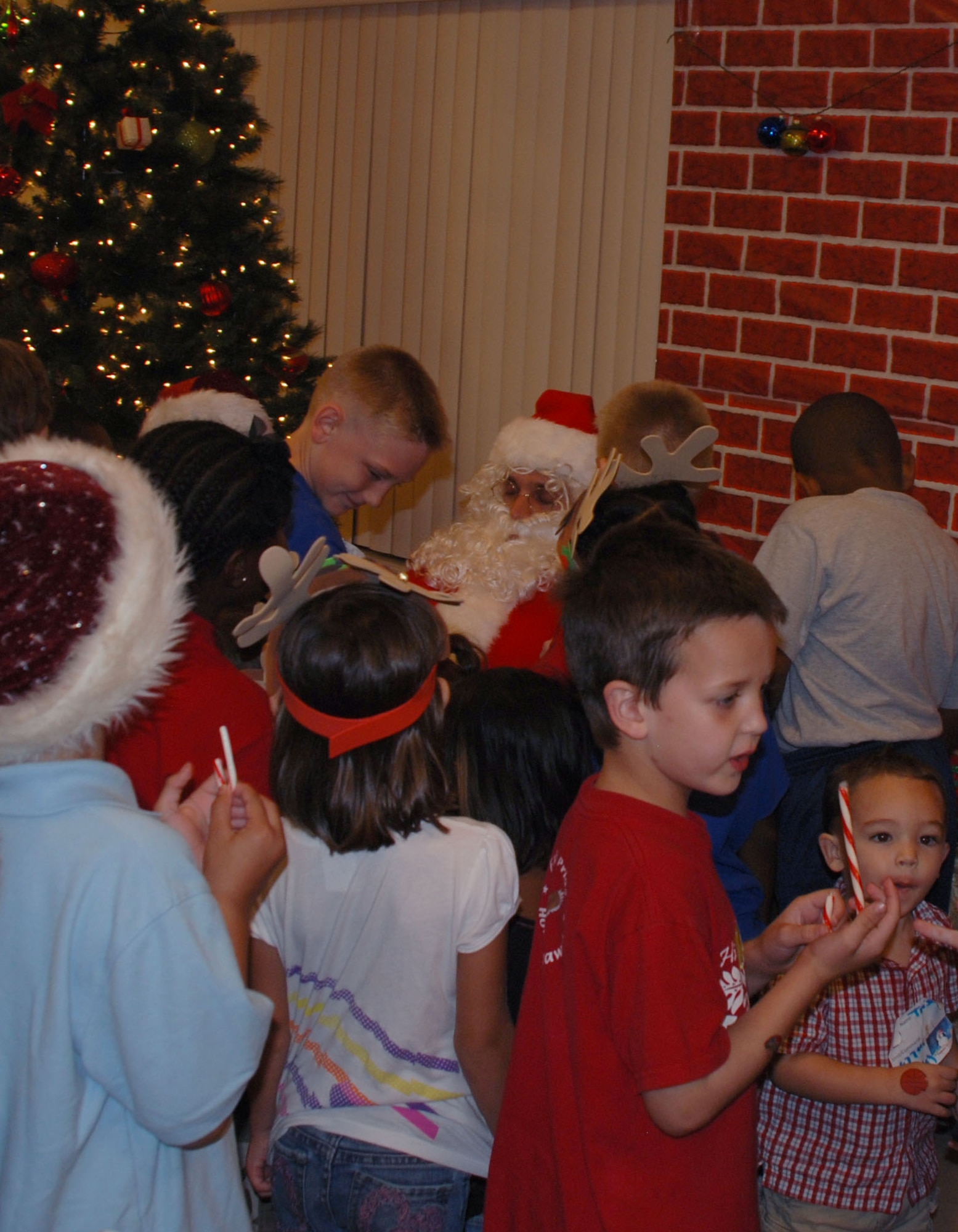 Children gather around Santa during the Deployed Spouse's Christmas Party Dec. 14 at the Hickam Communities Center, Joint Base Pearl Harbor-Hickam, Hawaii. The 647th Air Base Group, with Warfighter Family Readiness Services, hosted the party. More than 55 families, including 111 children attended. Col. Rusty Baumgardner, 647 ABG commander and JBPH-H deputy commander, and many other key leaders provided entertainment and support for families in attendance. Miss Teen South Pacific World 2011 Cassie Sumimoto read a Christmas story to the children. The evening concluded with a visit from Santa Clause who provided a present to each of the good boys and girls at the party. (U.S. Air Force photo/Tech. Sgt. Anthony O'Brien)