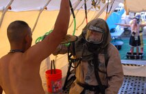 Hawaii National Guardsmen dressed in Mission Oriented Protective Posture gear decontaminate the "victim" of a dirty bomb explosion during a Homeland Defense Response validation exercise at Bellows Air Force Station, Hawaii, Dec. 16, 2010.  (U.S. Air Force photo/Staff Sgt. Carolyn Viss)
