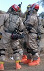 Hawaii National Guardsmen dressed in Mission Oriented Protective Posture gear look for victims amid the rubble of a dirty bomb explosion site during a Homeland Defense Response validation exercise at Bellows Air Force Station, Hawaii, Dec. 16, 2010.  (U.S. Air Force photo/Staff Sgt. Carolyn Viss)