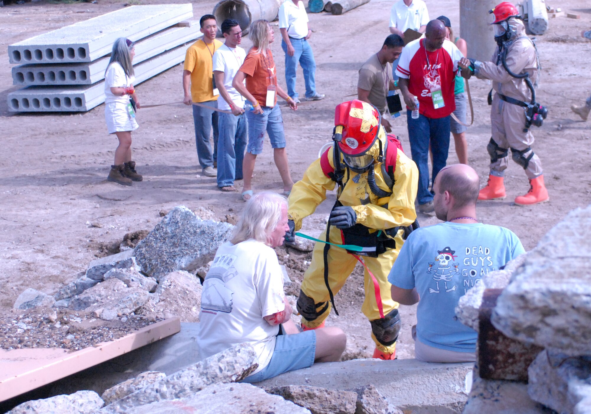 Hawaii National Guardsmen dressed in Mission Oriented Protective Posture gear assist "victims" of a dirty bomb explosion during a Homeland Defense Response validation exercise at Bellows Air Force Station, Hawaii, Dec. 16, 2010.  (U.S. Air Force photo/Staff Sgt. Carolyn Viss)