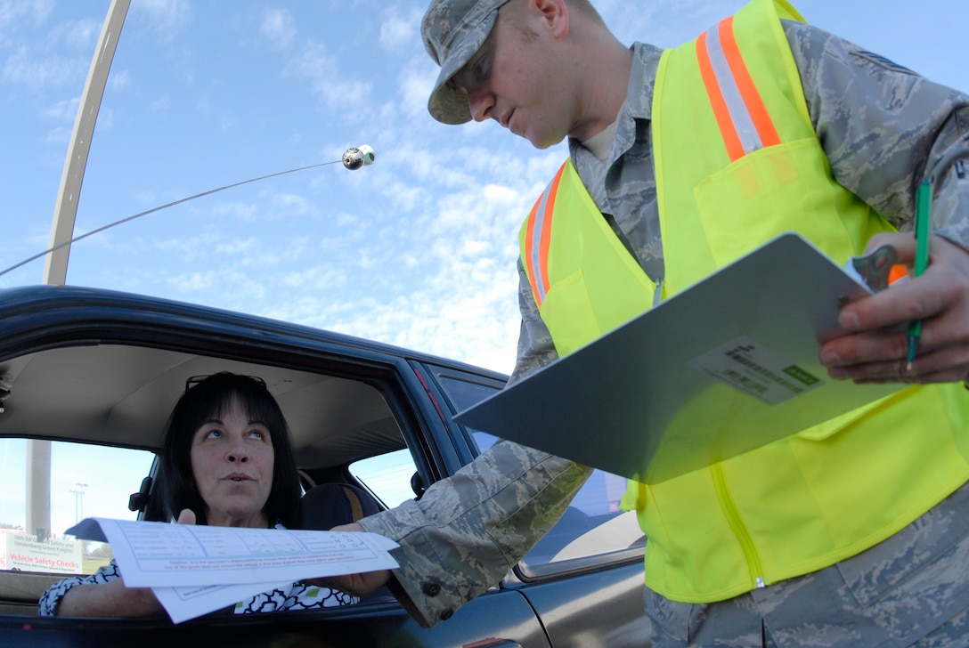 VANDENBERG AIR FORCE BASE, Calif. -- Staff Sgt. Michael Ferguson, a 30th Space Wing occupational safety and health specialist, hands a vehicle inspection checklist to a motorist at the Army and Air Force Exchange Service gas station here Thursday, Dec. 16, 2010.  The base's safety office performed free safety checks on vehicles in which they looked at tire pressure, fluids and the lights to ensure they were in proper working condition.  (U.S. Air Force photo/Senior Airman Andrew Satran) 

 
  