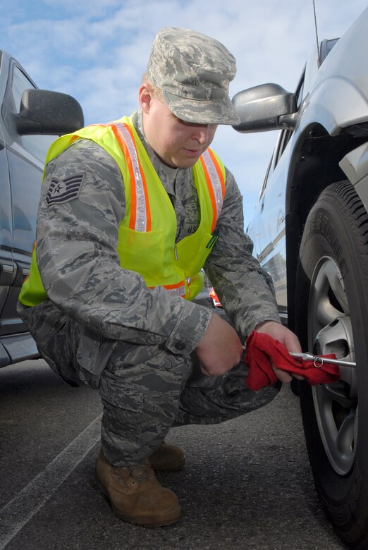 VANDENBERG AIR FORCE BASE, Calif. -- Checking the tire pressure, Tech. Sgt. Hyrum Lowder, a 30th Space Wing NCO in charge of ground safety, finishes his vehicle inspection at the Army and Air Force Exchange Service gas station here Thursday, Dec. 16, 2010.  The 30th Space Wing Safety Office performed free vehicle inspections for Team V to help assess potential risks for motorists.  (U.S. Air Force photo/Senior Airman Andrew Satran) 

  