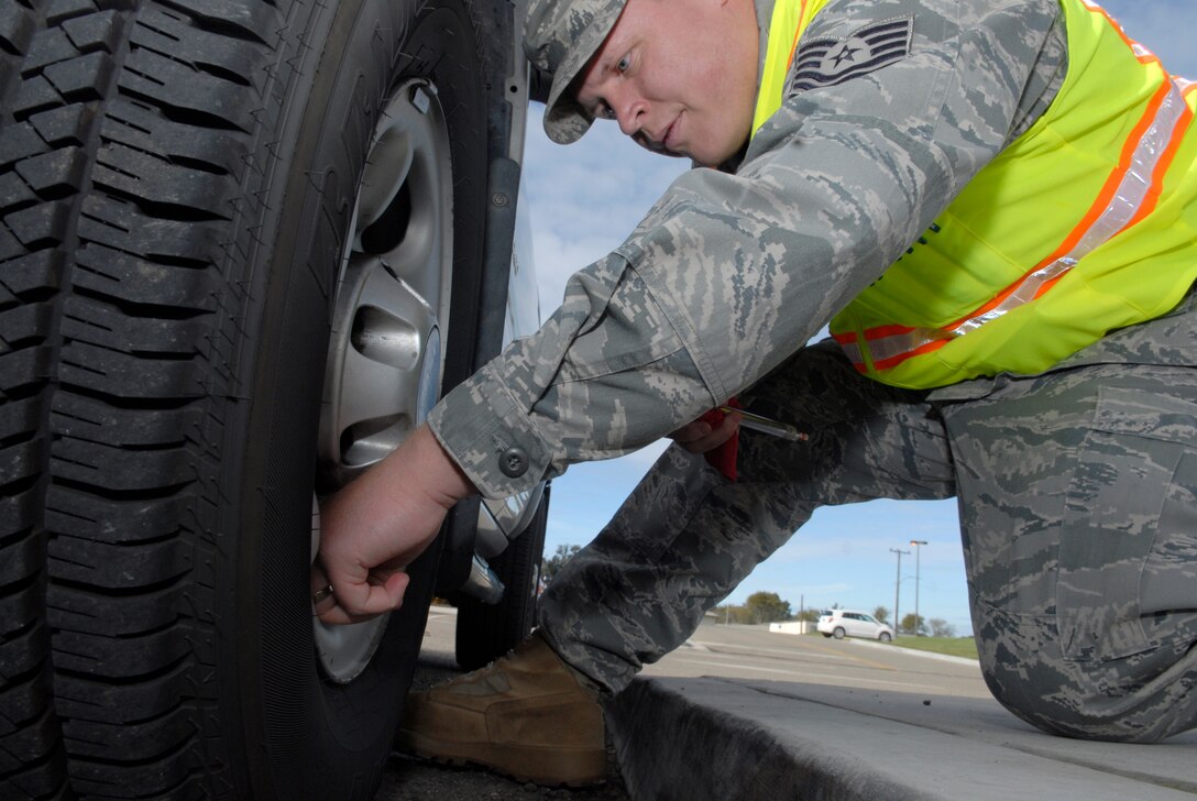 VANDENBERG AIR FORCE BASE, Calif. -- Checking the tire pressure, Tech. Sgt. Hyrum Lowder, a 30th Space Wing NCO in charge of ground safety, finishes his vehicle inspection at the Army and Air Force Exchange Service gas station here Thursday, Dec. 16, 2010.  The 30th Space Wing Safety Office performed free vehicle inspections for Team V to help assess potential risks for motorists.  (U.S. Air Force photo/Senior Airman Andrew Satran) 

 