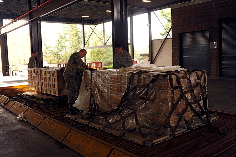 Airmen assigned to the 62nd Aerial Port Squadron secure ammo to pallets before loading it onto a C-17 Globemaster III Dec. 15 at McChord Field, Joint Base Lewis-McChord, Wash. The ammo will be delivered to the Middle East for missions supporting Operation Enduring Freedom. (U.S. Air Force photo/Adamarie Lewis-Page)