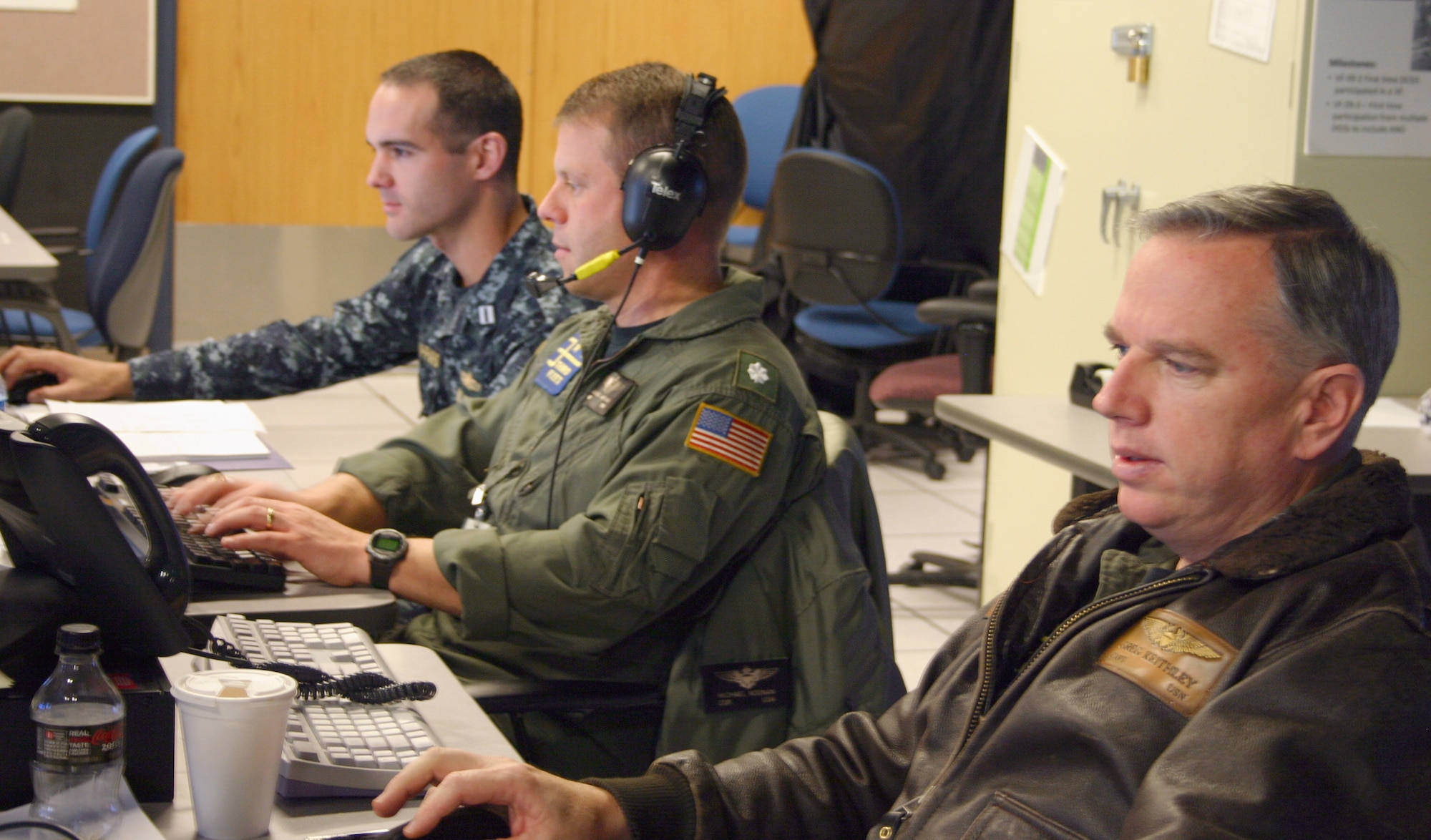 (From left) Navy Lt. Justin Sheppard, Navy Cmdr. Michael Noonan and Navy Capt. Greg Keithley, from Third Fleet stationed at San Diego, coordinate naval support in the Maritime Operating Center during Virtual Flag 11-1, hosted by the 705th Combat Training Squadron at Kirtland Air Force Base, N.M. More than 300 joint warfighters at 18 locations from Japan to England converged in a virtual battlespace for a four-day exercise ending Dec. 16, 2010. With a price tag of $2 million, it would cost 20 times that for a similar exercise with live aircraft, according to a recent 705th CTS study. (U.S. Air Force photo)