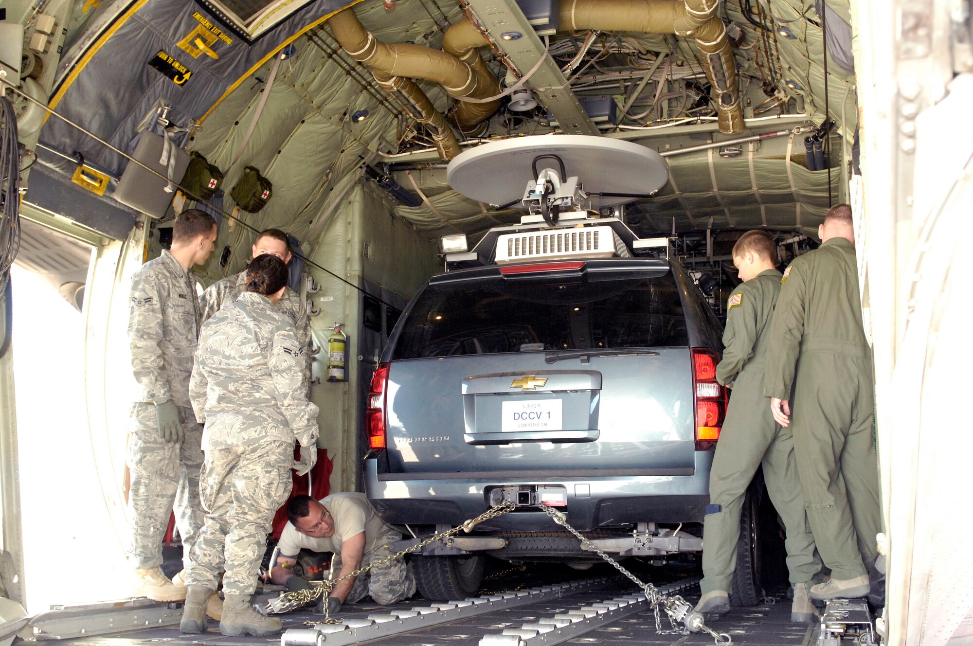 PETERSON AIR FORCE BASE, Colo. - Air crew and loadmasters with the 302nd Airlift Wing and members of the U.S. Northern Command Standing Joint Force Headquarters tightly secure the SJFHQ's Emergency Response Vehicle in the back of a C-130 cargo plane Dec. 13. The ERV is one of the tools the SJFHQ uses to rapidly deploy force package in response to crises or events across the nation such as the 2008 wildfires and the responses to Hurricanes Gustav, Ike and Hanna.  It allows
deployedelements of the SJFHQ to communicate through secure and non-secure systems with every echelon of command and maintain situational awareness through
open source reporting. A smaller vehicle than its predecessor, the ability to
load and transport the ERV via C-130 greatly contributes to SJFHQ's ability to rapidly deploy anywhere in the USNORTHCOM Area of Responsibility. (Photo by Jhomil Bansil)

