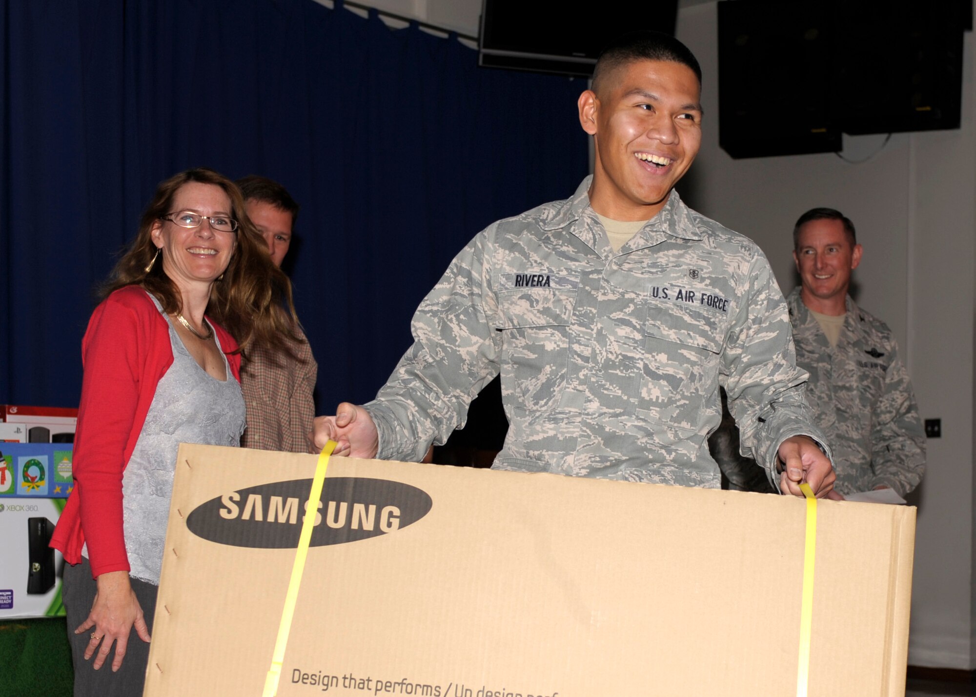 Airman Reymer Rivera, 27th Special Operations Areospace Medicine Squadron,  accepts his prize of a 32" flat screen TV during the Single Airman's Dinner at the Drop Zone, Dec. 14. Other prizes were given away included Ipods, Wii's and $100 gift cards. (U.S. Air Force Photo by Airman Ericka Engblom) 