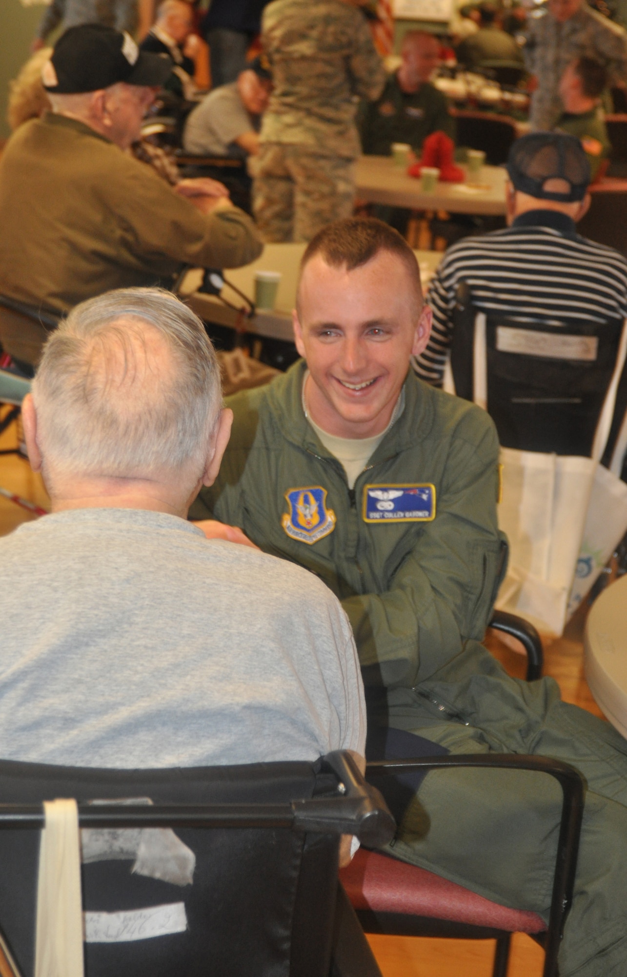 Staff Sgt. Cuillen Gardner, 337th Airlift Squadron, talks with a senior citizen at the Holyoke Soldier's Home Dec. 17. Sergeant Gardner was among more than 30 Westover Airmen who visited the veterans as part of an annual visit. (US Air Force photo/Master Sgt. Andrew Biscoe)