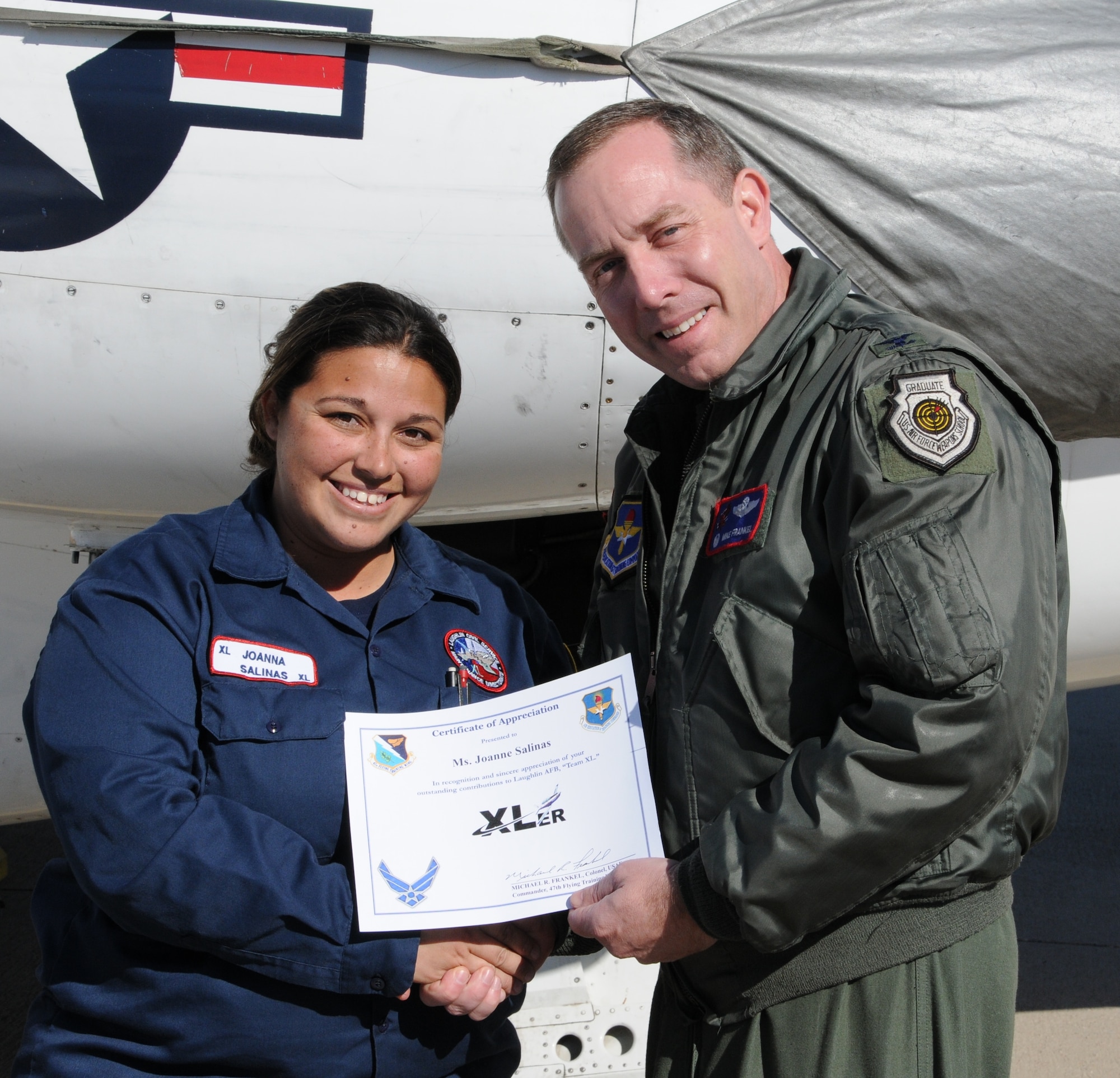 LAUGHLIN AIR FORCE BASE, Texas – Joanna Salinas, 47th Maintenance Directorate, is presented the XLer of the Week award by Col. Michael Frankel, 47th Flying Training Wing commander on Laughlin’s flight line Dec. 15. The XLer is a weekly award chosen by wing leadership and given to individuals who consistently make outstanding contributions to Laughlin and their unit. (U.S. Air Force photo by Airman 1st Class Blake Mize)
