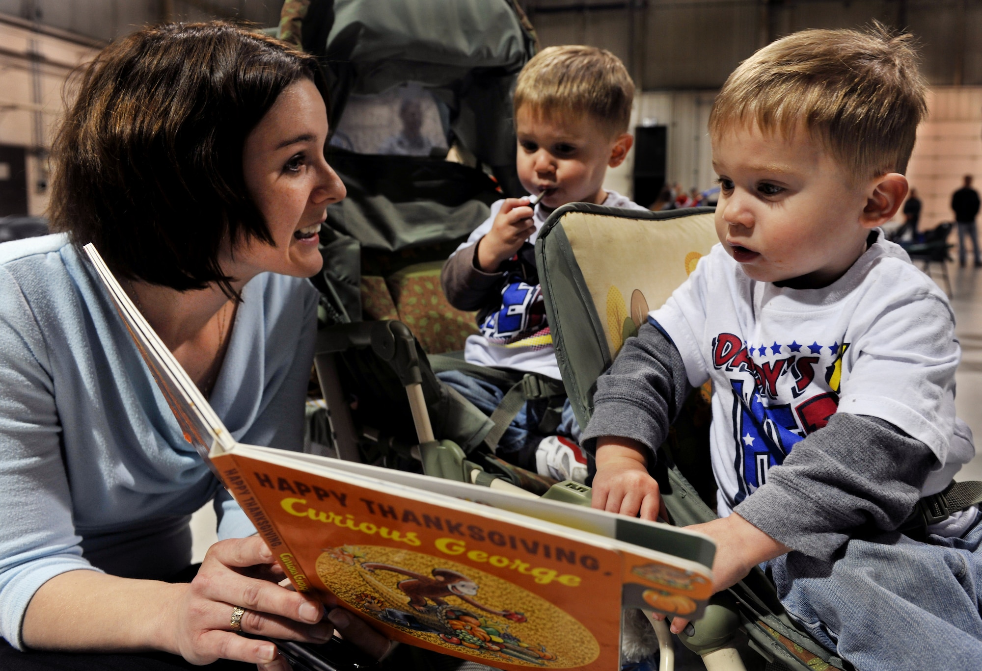MOODY AIR FORCE BASE, Ga.-- Audrey Mazzotta, wife of Staff Sgt. Thomas Mazzotta, 23rd Aircraft Maintenance Squadron crew chief, reads to her two sons, Micca and Maverick, during a redeployment Dec. 16. Mrs. Mazzotta said it has been challenging during her husband’s deployment but now he is home just in time for their children’s second birthday. (U.S. Air Force photo/Airman 1st Class Joshua Green)(RELEASED)

