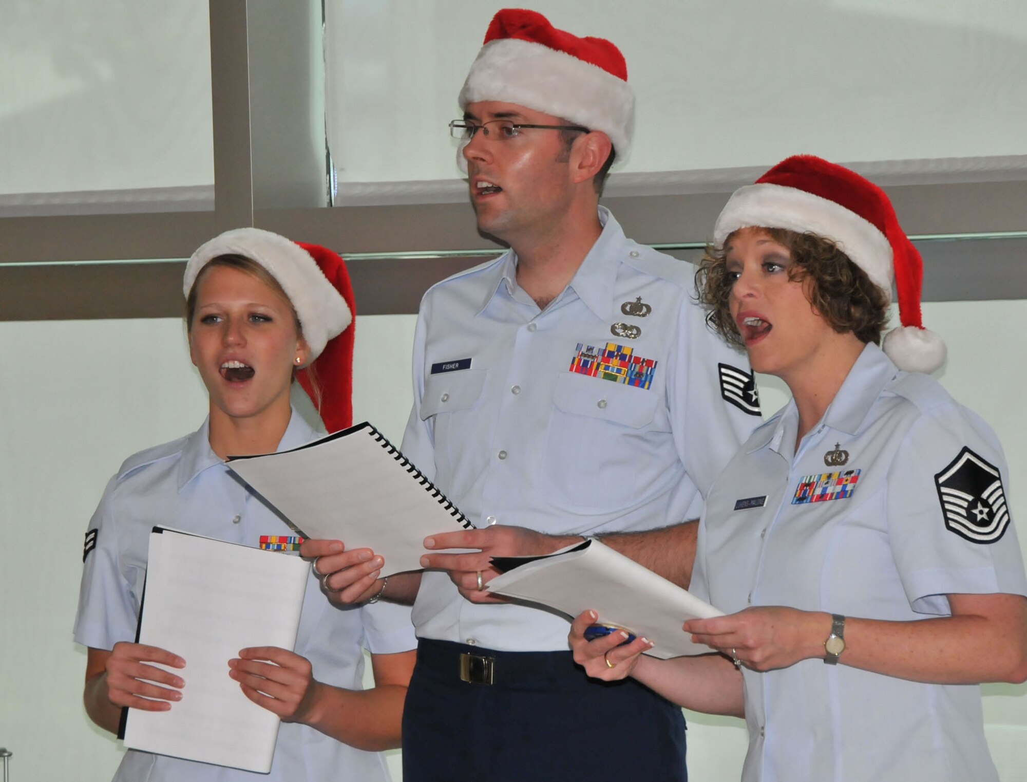 Three singers from the Air Force Band of the Golden West  spread holiday cheer by singing to customers waiting for ID cards at LAAFB, Dec. 13. The group was here on the band’s annual tour to bases on the west coast and performed in front of more than 300 people at various stops on base.  (Photo by Lou Hernandez)