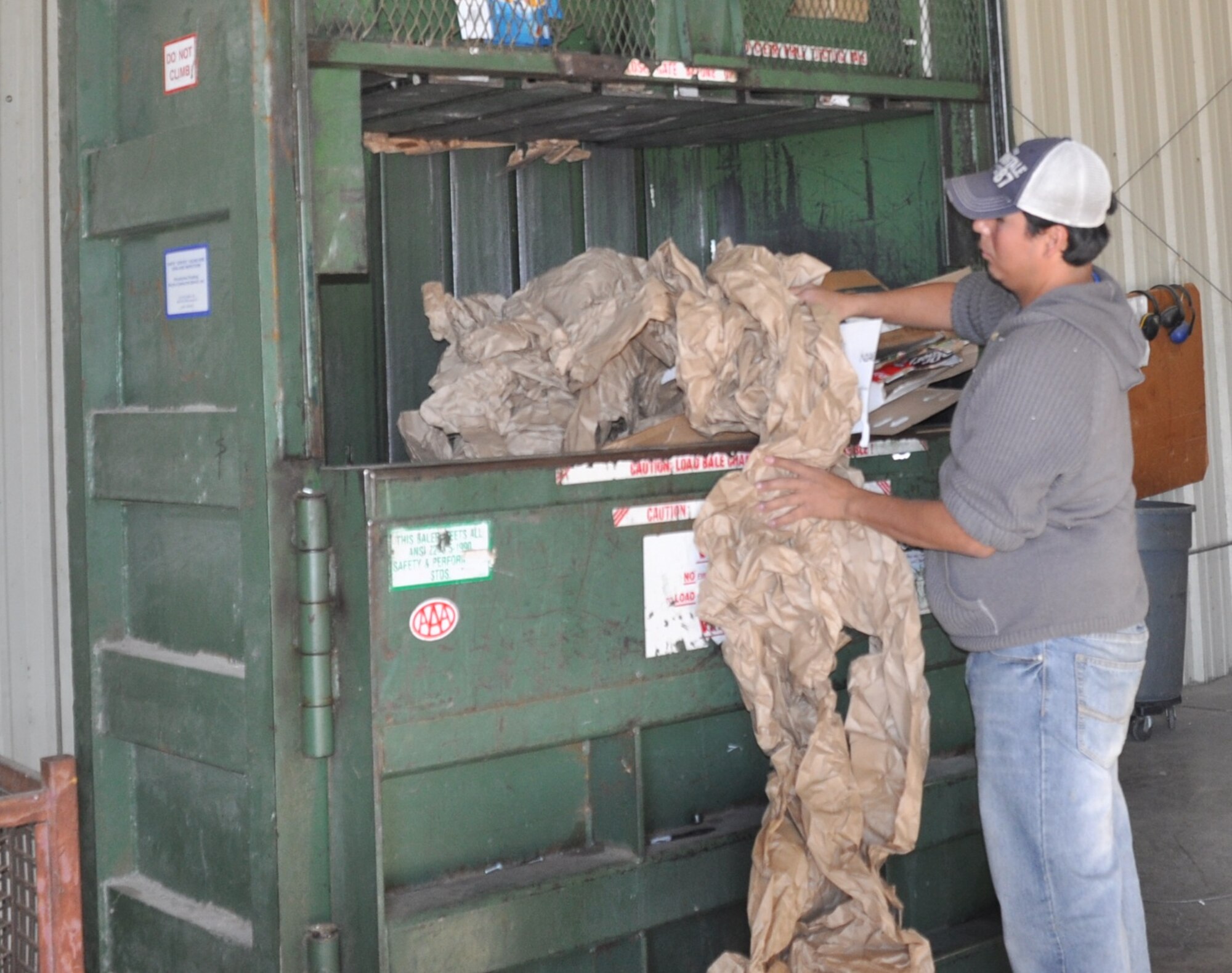 LAUGHLIN AIR FORCE BASE, Texas—Rolando Deleon, a Laughlin recycling center associate, puts paper into one of the center’s five bailers. The bailer then compresses the material into a 1,000 to 1,200 pound bail that is transported to San Antonio for recycling. (U.S. Air Force photo by 2nd Lt. Angela Martin)