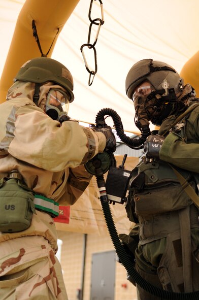 MOODY AIR FORCE BASE, Ga. -- Tech. Sgt. Evelinda Lombard, 23rd Operations Support Squadron aircrew flight equipment journeyman, removes equipment off of Maj. Bryan Nickola, 23rd Fighter Group A-10C Thunderbolt II pilot, in zone II of decontamination stations Dec. 17. In zone II of the course, aircrew flight equipment technicians must remove all chemical warfare gear. (U.S. Air Force photo/Airman 1st Class Douglas Ellis)(RELEASED)