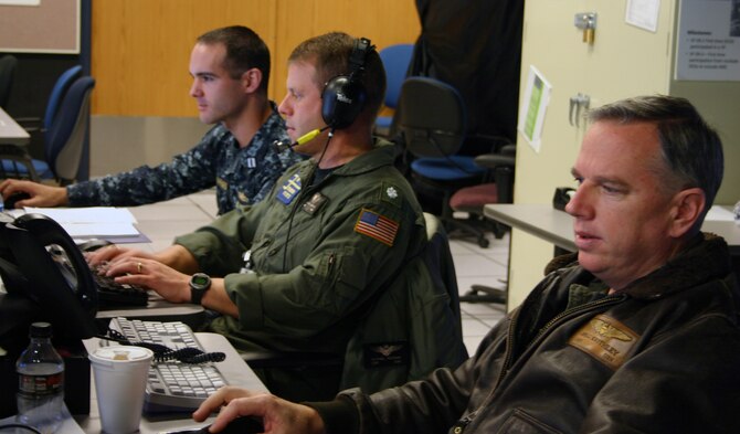From left, U.S. Navy Lt. Justin Sheppard, Cmdr. Michael Noonan and Capt. Greg Keithley, from Third Fleet stationed at San Diego, coordinate naval support in the Maritime Operating Center, or MOC, during Virtual Flag 11-1 hosted by the 705th Combat Training Squadron, Kirtland Air Force Base, N.M. More than 300 Joint warfighters at 18 locations from Japan to England converged in a virtual battlespace over the Pacific for a four-day exercise ending Dec. 16. With a price tag of $2 million it would cost 20 times that for a similar exercise
with live aircraft, according to a recent 705th CTS study. (U.S. Air Force photo)
