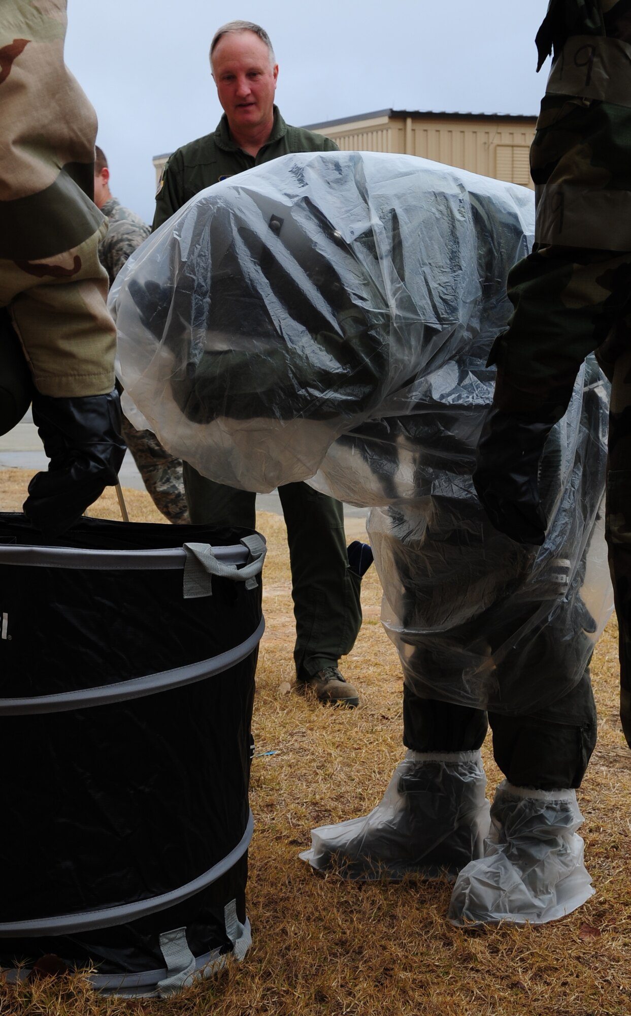 MOODY AIR FORCE BASE, Ga. -- A 23rd Fighter Group A-10C Thunderbolt II pilot, removes his overcape during a decontamination training Dec 17. The training is used to teach pilots of the decontamination process after an attack were to occur. (U.S. Air Force photo/Senior Airman Stephanie Mancha)(RELEASED)