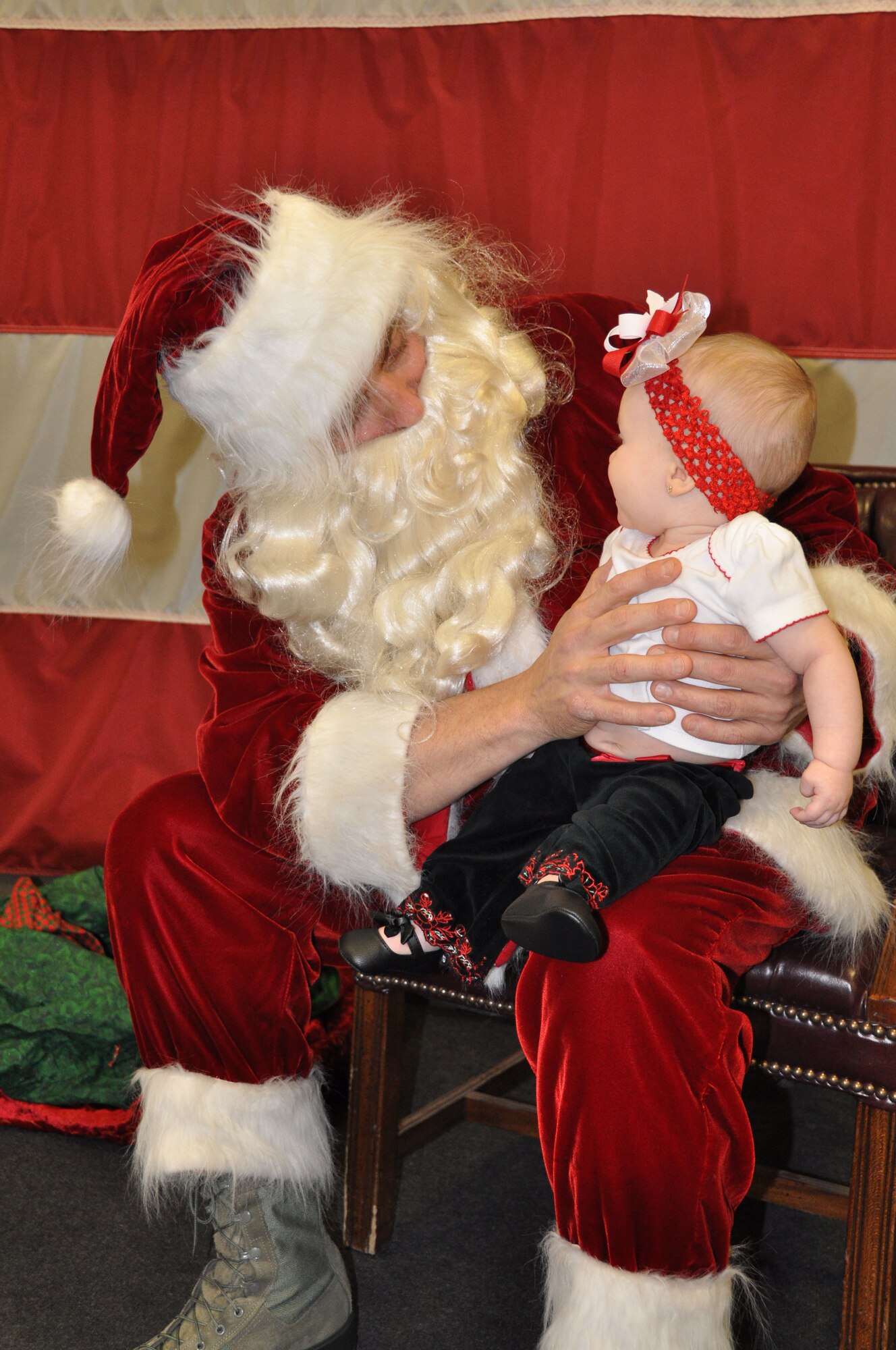 Little six-month-old Baylee Stonebraker takes a good look at Santa when they met for the very first time at the 419th FW’s annual Christmas party Dec. 16. Baylee is the daughter of Master Sgt. Lennon Stonebraker of the 419th Aircraft Maintenance Squadron. (U.S. Air Force photo/Kari Tilton)