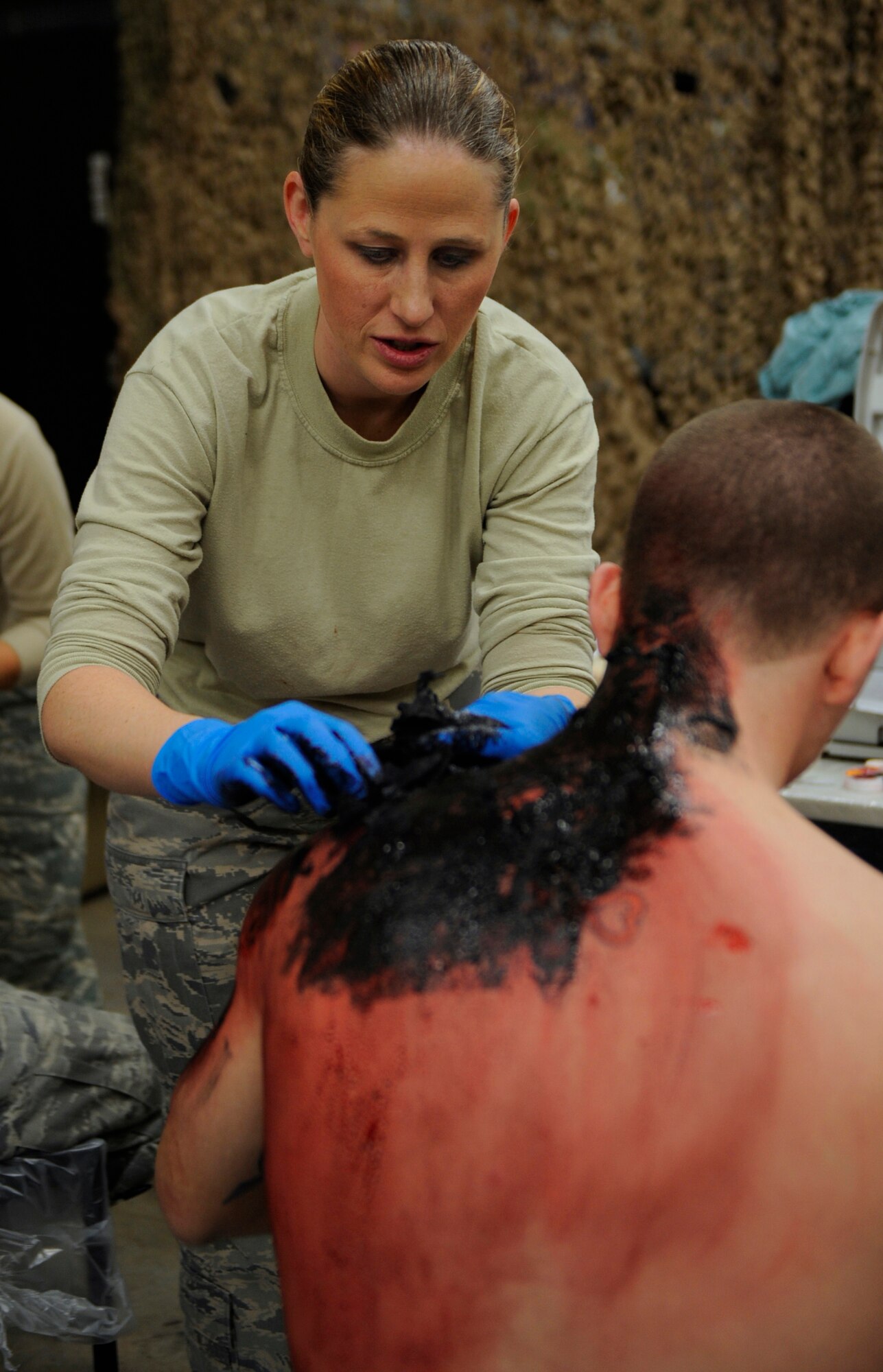 MOUNTAIN HOME AIR FORCE BASE, Idaho -- Tech. Sgt. Kari Boyles, 366th Dental Squadron superintendent, preps Airman 1st Class Ryan O'Quinn, 389th Aircraft Maintenance Unit F-15E apprentice, for the Emergency Response Exercise Dec. 14. EREs are held to ensure Airmen are prepared to protect people and resources during real-world situations.  (U.S. Air Force photo by Senior Airman Renishia Richardson) 