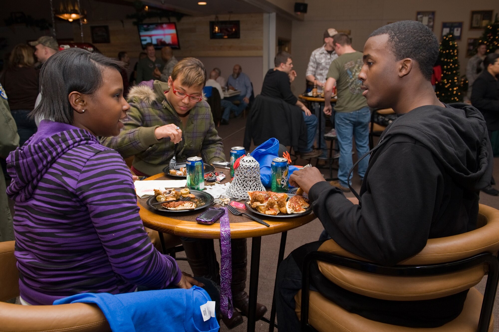 Free food was also featured at the Operation Holiday Cheer wrap-up party Dec. 8 at the Grizzly Bend Club. Pictured from left to right enjoying pizza and wings are Airmen 1st Class Toshika Morrison, 341st Missile Security Forces Squadron; Diamond Brooks, 341st Medical Operations Squadron; and Aaron Chalmers, 741st Missile Security Forces Squadron. (U.S. Air Force photo/Beau Wade)