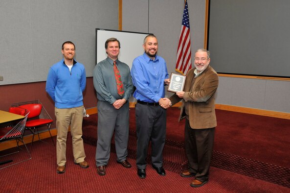 Kent Wilcher, third from left, accepts his plaque from Dustin Crider, Dr. Joseph Sheeley, and Tom Best Dec 14. Wilcher tied for third place in the Technical Poster Contest. (Photo by Rick Goodfriend)
