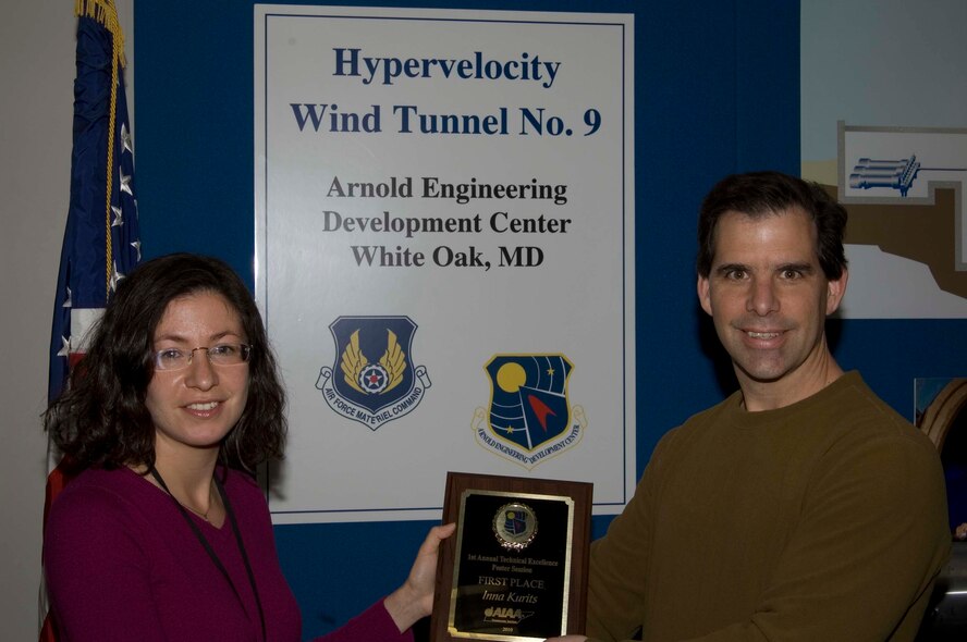 Inna Kurits receives her first place award in the Technical Poster Contest from AEDC Tunnel 9 Director Dan Marren Dec. 13. (Photo provided)