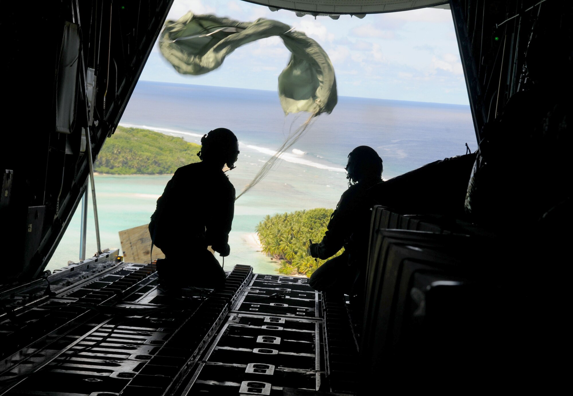 Airmen from the 36th Airlift Squadron, Yokota Air Base, Japan, watch as the parachute deploys and a box of humanitarian goods travels to the Yap Islands below during Operation Christmas Drop, Dec. 14, 2010. Operation Christmas Drop is the Air Force's longest-running humanitarian which began in 1952. What started as a WB-50 aircrew returning to Guam on its final flight before Christmas has turned into the longest running humanitarian campaign in the history of the U.S. Air Force and the entire world. (U.S. Air Force photo/Senior Airman Nichelle Anderson) 
