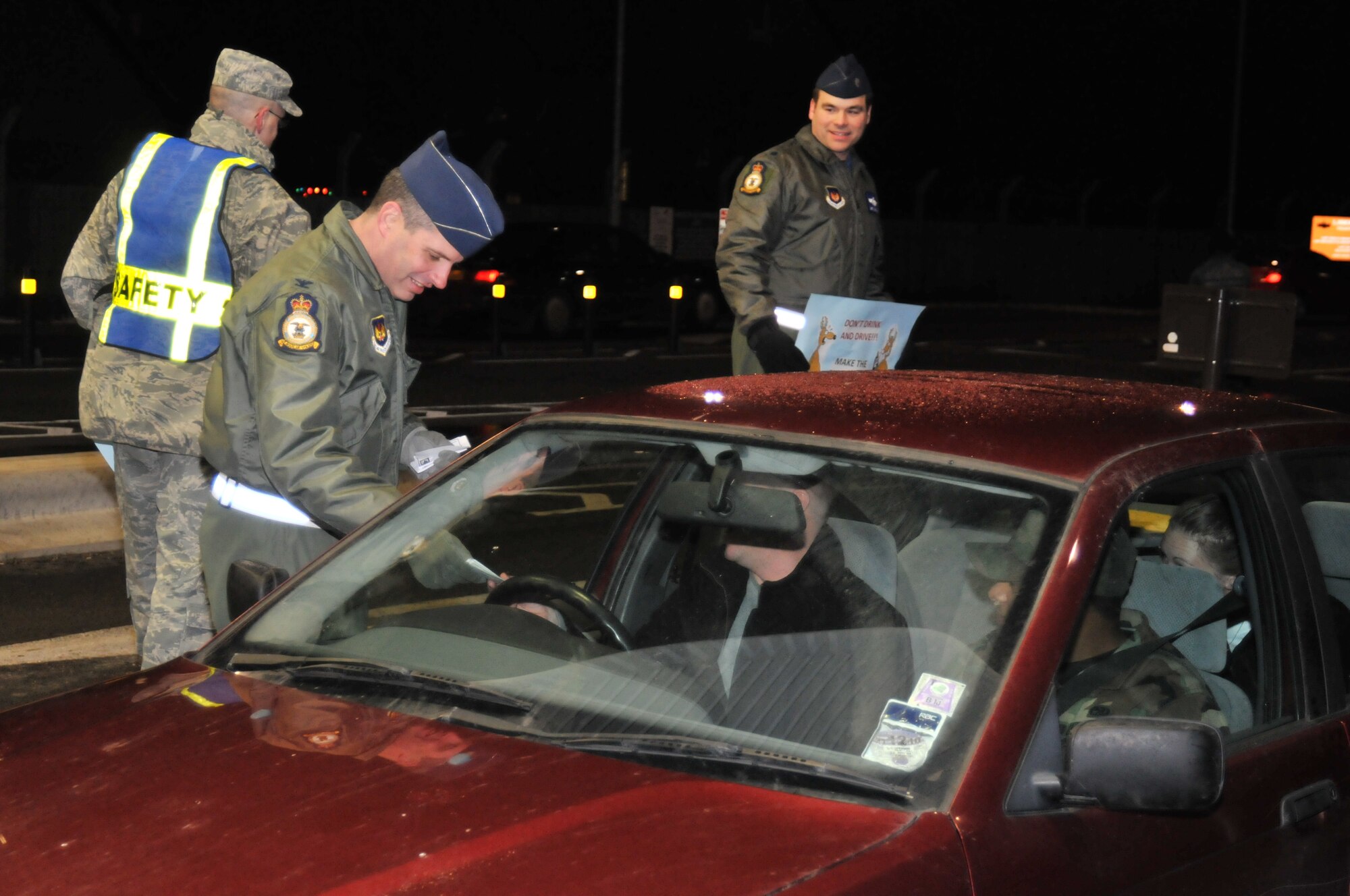 ROYAL AIR FORCE LAKENHEATH, England -- Col. William Lewis, 48th Fighter Wing vice commander, hands out safety cards to motorists arriving on base Dec. 17. The 48th FW Safety office encourages all drivers to practice safe driving habits this holiday season. (U.S. Air Force photo/Senior Airman David Dobrydney)