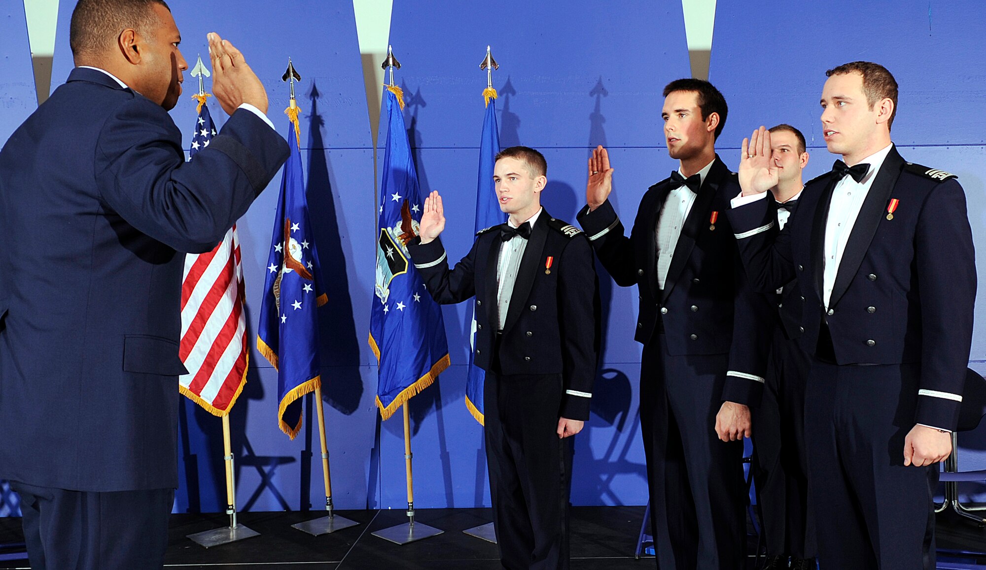 State your name: Brig. Gen. Richard Clark administers the oath of office to Cadets 1st Class Mikhail Fedorchik, Andrew Herzog and Sean Lipkin before the three receive their commissions as second lieutenants during a graduation ceremony at the Air Force Academy Dec. 15, 2010. In the background is Cadet 1st Class Mathew Haxton, one of three cadets who graduated without receiving commissions. (U.S. Air Force photo/Mike Kaplan)