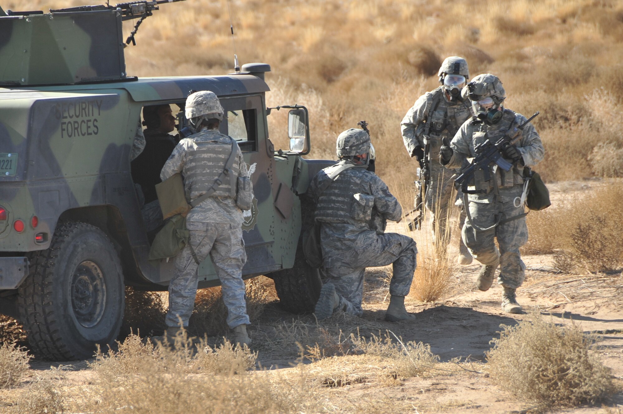 Airmen take cover behind a vehicle during the exercise. U.S. Air Force Photo by Todd Berenger.