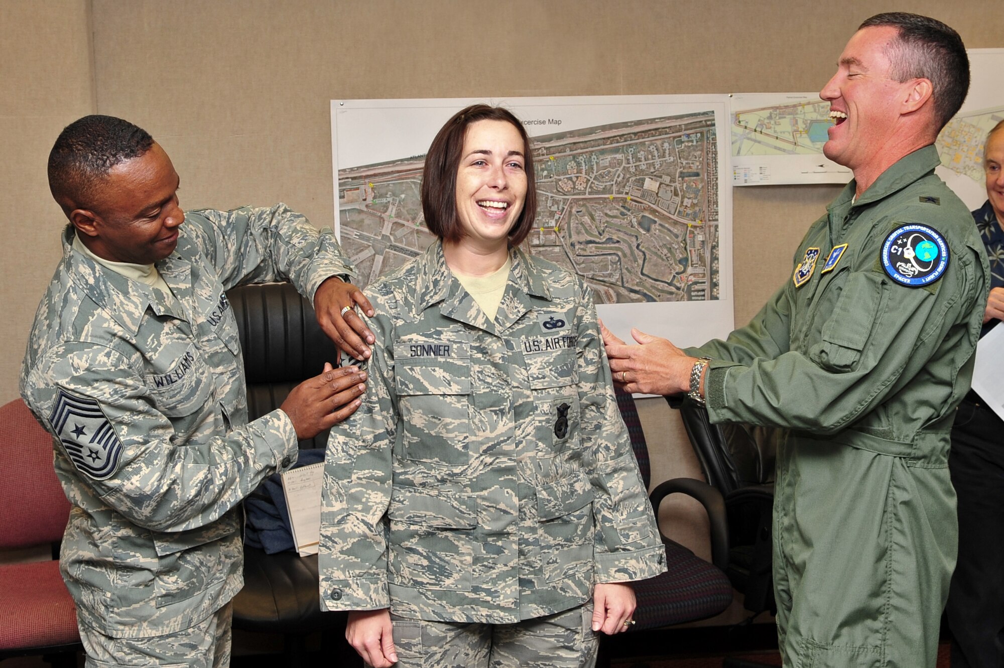 PATRICK AIR FORCE BASE, Fla -- Each year the Air Force grants less than 200 slots for Stripes for Exceptional Performers (STEP) promotions.  This year, Staff Sgt. Jessica
Sonnier (center) of the 45th Space Wing Security Forces Squadron was selected for a STEP promotion and her Tech. Sgt. Stripe, which Brig. Gen. Ed Wilson (right), 45th SW commander,  and Command Chief Master Sgt. Calvin
Williams (left) were more than happy to "punch" on for her here Dec. 10.  (U.S. Air Force photo by Jennifer Macklin)
