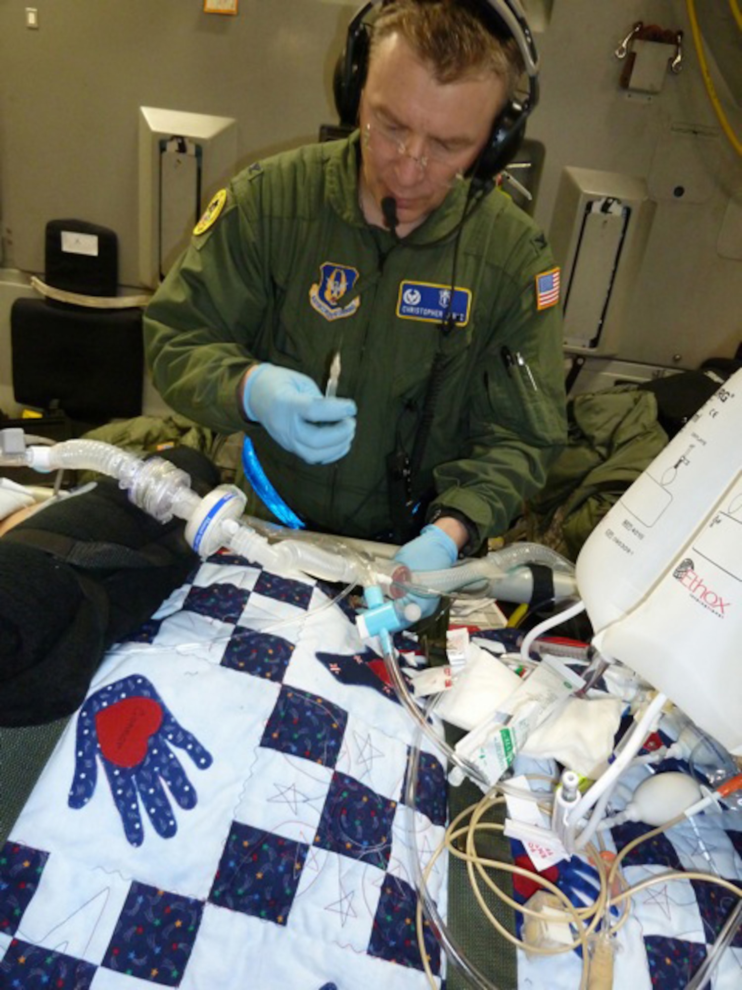 315th Aerospace Medicine Squadron Commander Col. Christopher "Doc" Lentz administers medication to one of his patients furing an aeromedical evacuation from Germany to the United States aboard a C-17. (Air Force Photo/315th Airlift Wing)
