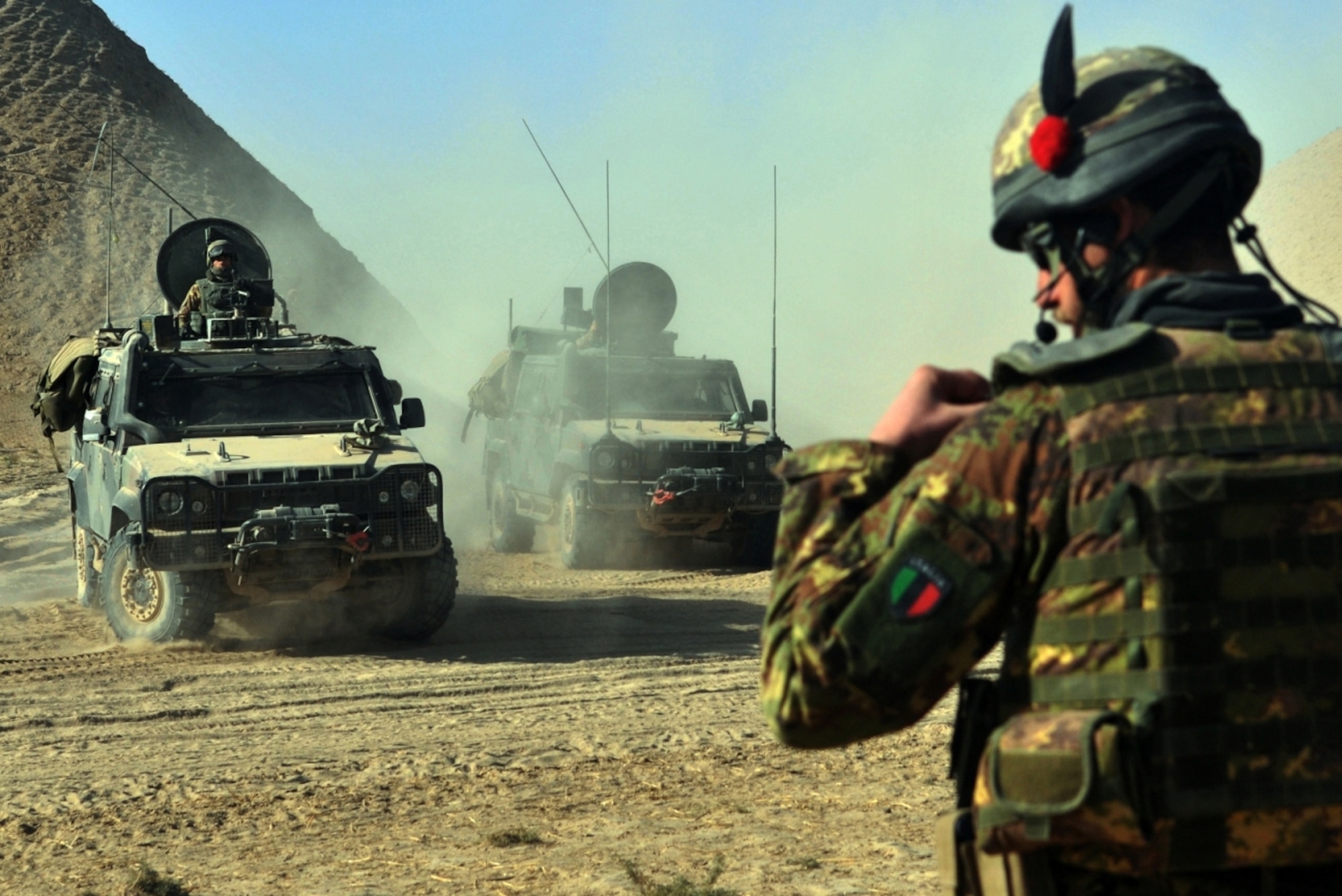 Italian Army Lt. Andrea Gilli, 6th Company platoon commander, utilizes his communication headset to order his soldiers into a defensive posture near Combat Outpost Victor, Badghis province, Afghanistan, Dec. 8. Just as the joint Italian-Afghan National Army convoy passed the bubble’s perimeter, they struck an improvised explosive device. Soon after that, they defeated waves of insurgent attacks while troops up on the mountaintop at COP Victor provided suppressive fire and over watch. (U.S. Air Force photo/Tech. Sgt. Kevin Wallace)