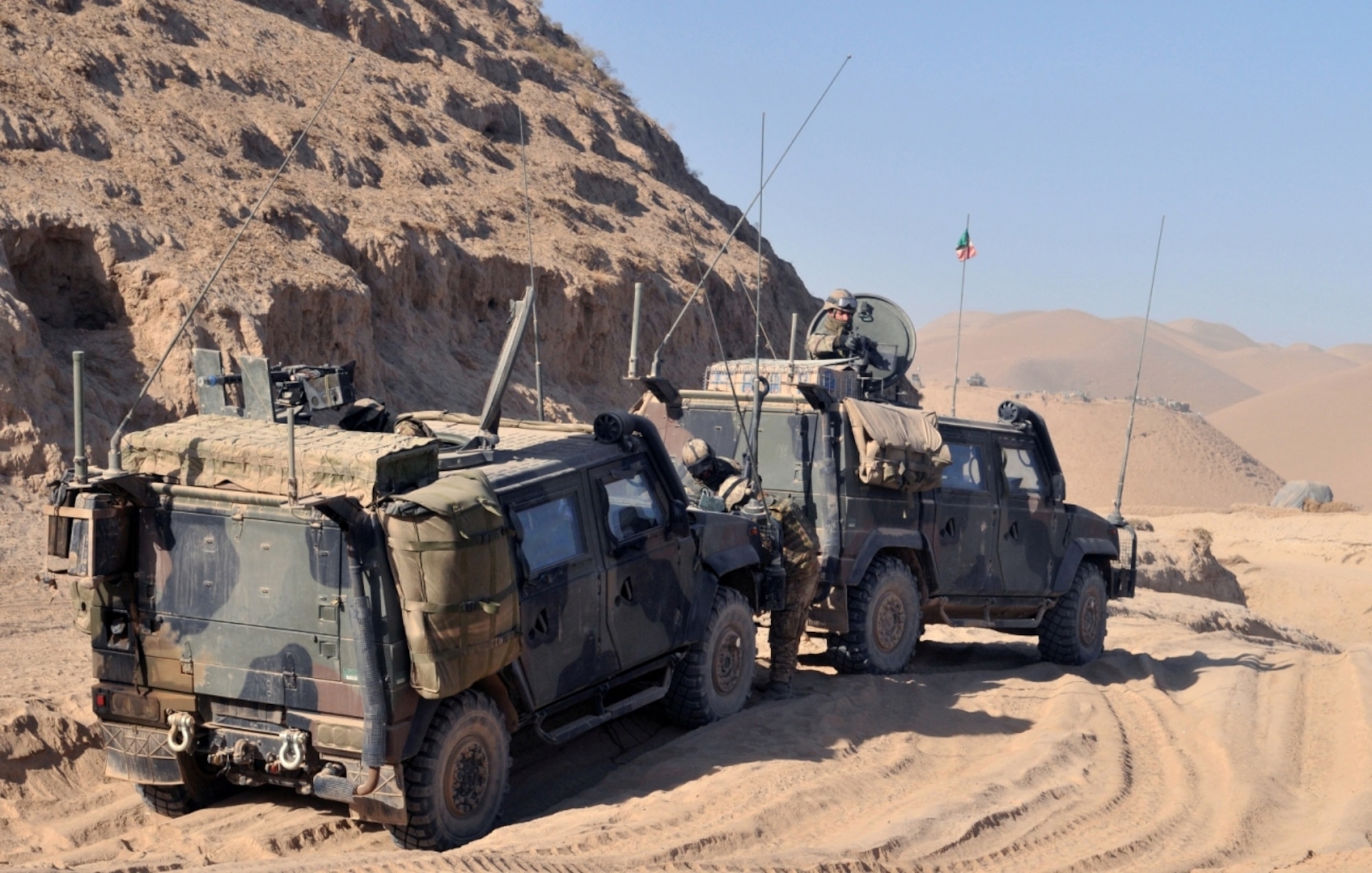 Soldiers secure a battlespace along a roadside near Combat Outpost Victor, Badghis province, Afghanistan, Dec. 8., and prepare to tow a broke-down vehicle. Afghan National Army soldiers take an over-watch position and help protect the Italian convoy. (U.S. Air Force photo/Tech. Sgt. Kevin Wallace)