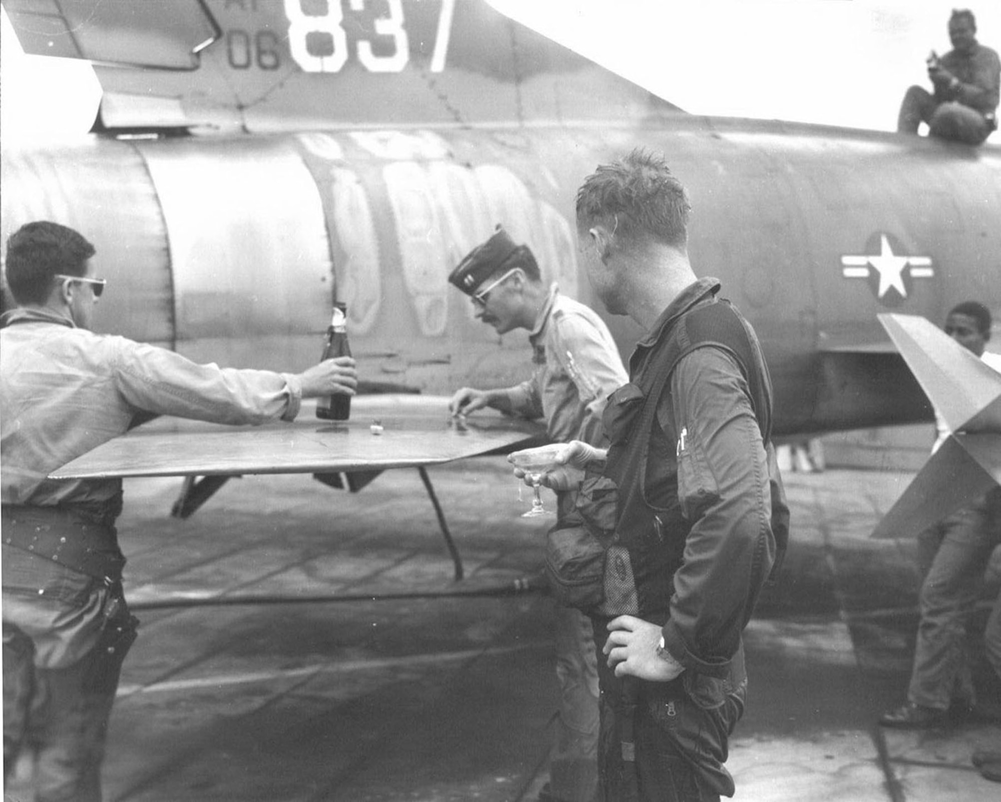 On March 18, 1968, Capt. James “Ed” Risinger finished his Misty FAC tour in the F-100F that is on display at the National Museum of the U.S. Air Force (S/N 56-3837). Capt. Risinger, holding a glass of champagne, celebrates his 58th and final mission. On the left is Capt. Brian Williams and inspecting bullet damage is Capt. Richard Rutan. (U.S. Air Force photo)