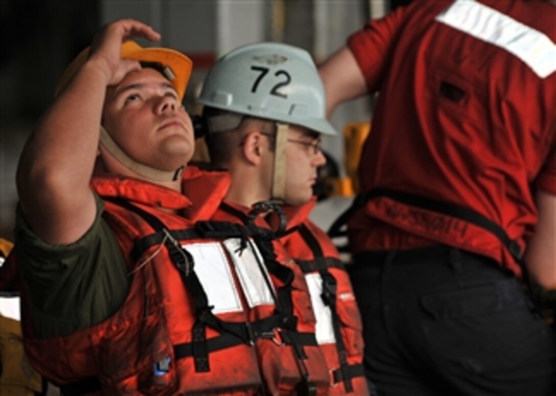 Petty Officer 3rd Class Edwin Pastrana looks up while waiting to help receive stores during a replenishment at sea aboard the aircraft carrier USS Abraham Lincoln (CVN 72) underway in Arabian Sea on Dec. 16, 2010.  The Abraham Lincoln Carrier Strike Group is deployed in the U.S. 5th Fleet area of responsibility supporting maritime security operations and theater security cooperation efforts.  